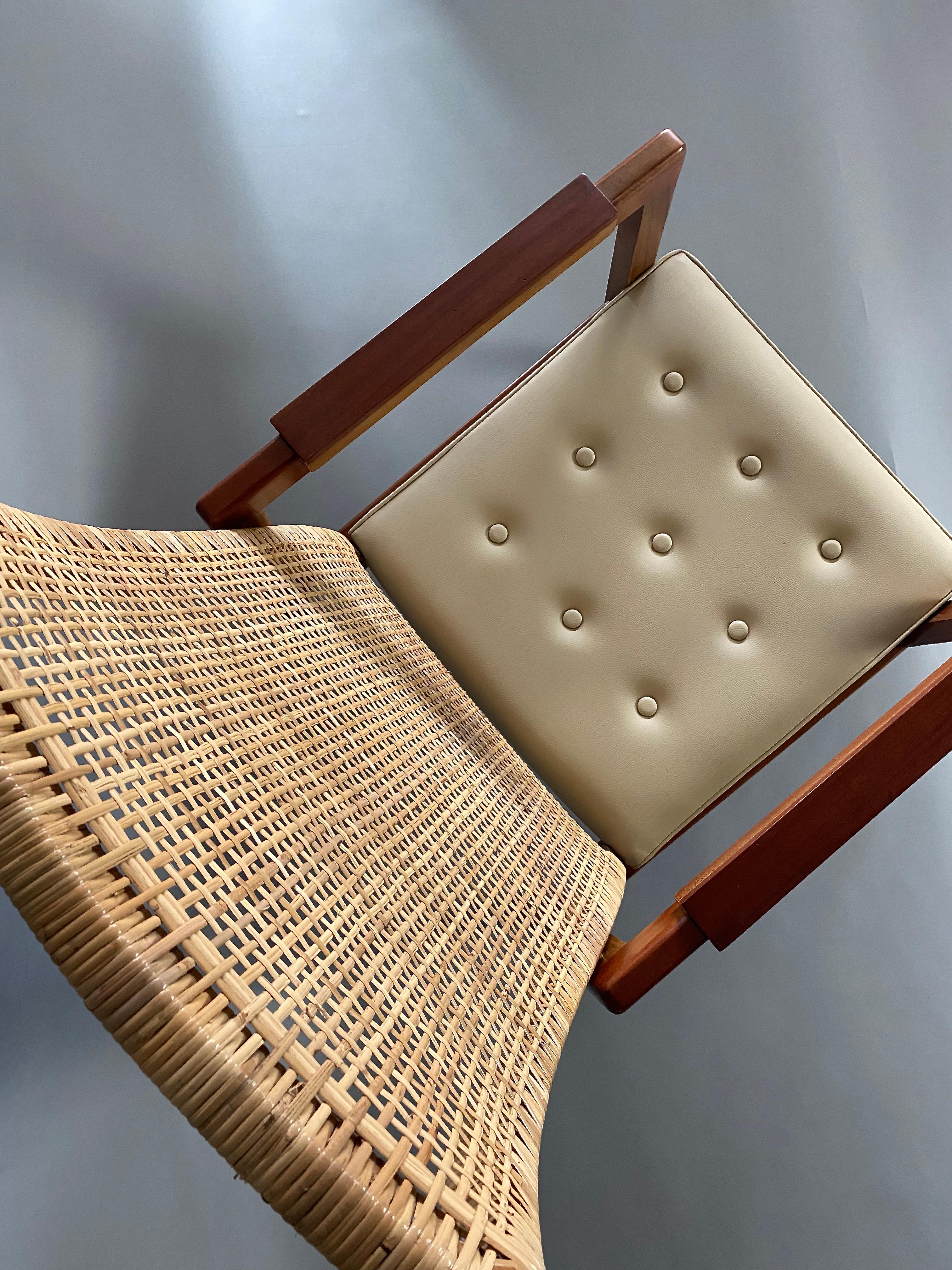Stylish and classy set of Mid-Century Modern lounge chairs in great condition. These elegant chairs have beautiful webbed cane curved backrests all intact. The ivory colored comfortable faux leather cane seat cushions are also in great condition as