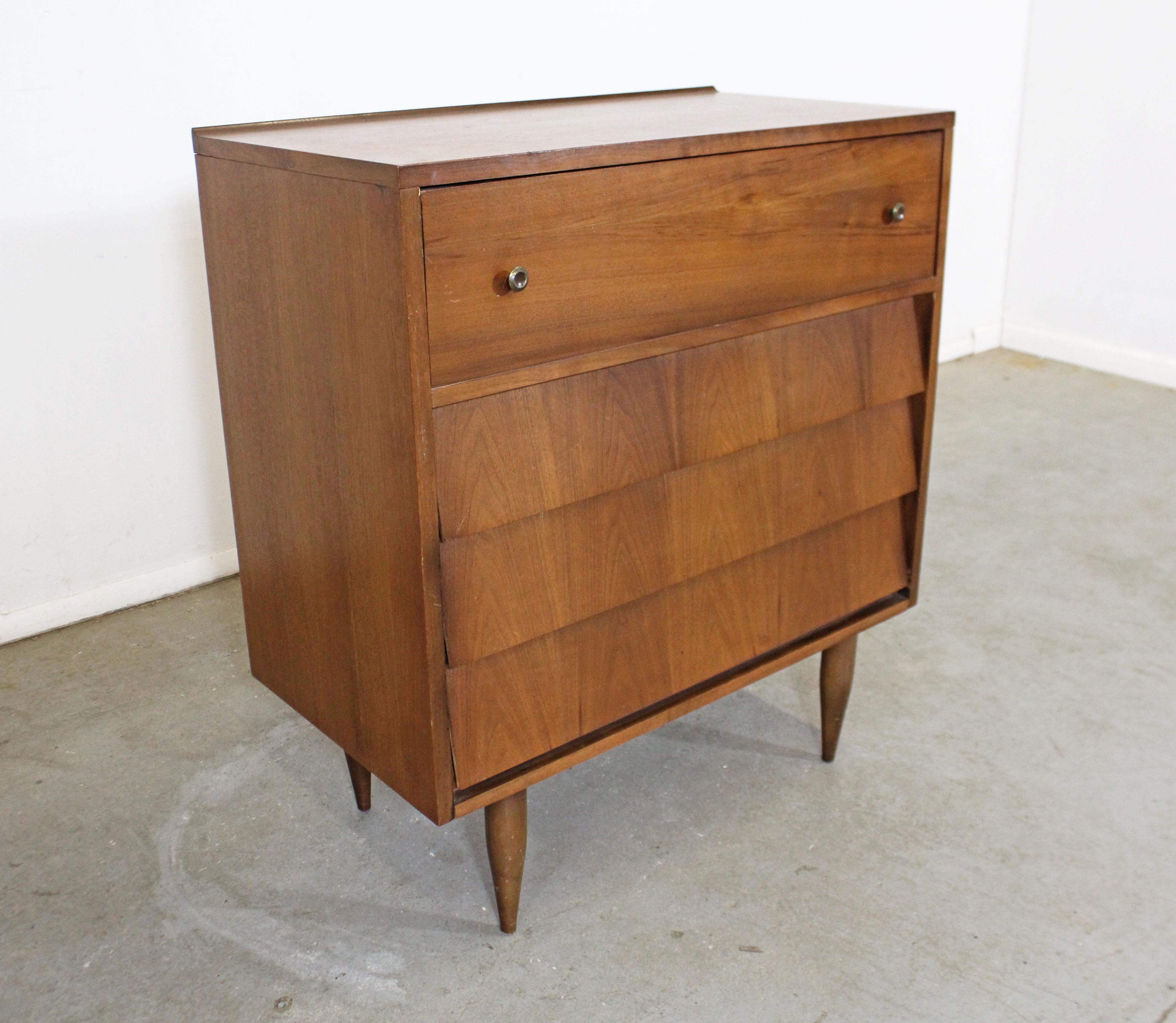 Offered is a vintage Mid-Century Modern tall chest by Harmony House. Features a louvered front with four dovetailed drawers and a sculpted top. The bottom three drawers have hidden pulls. It is in good vintage condition with some surface scratches