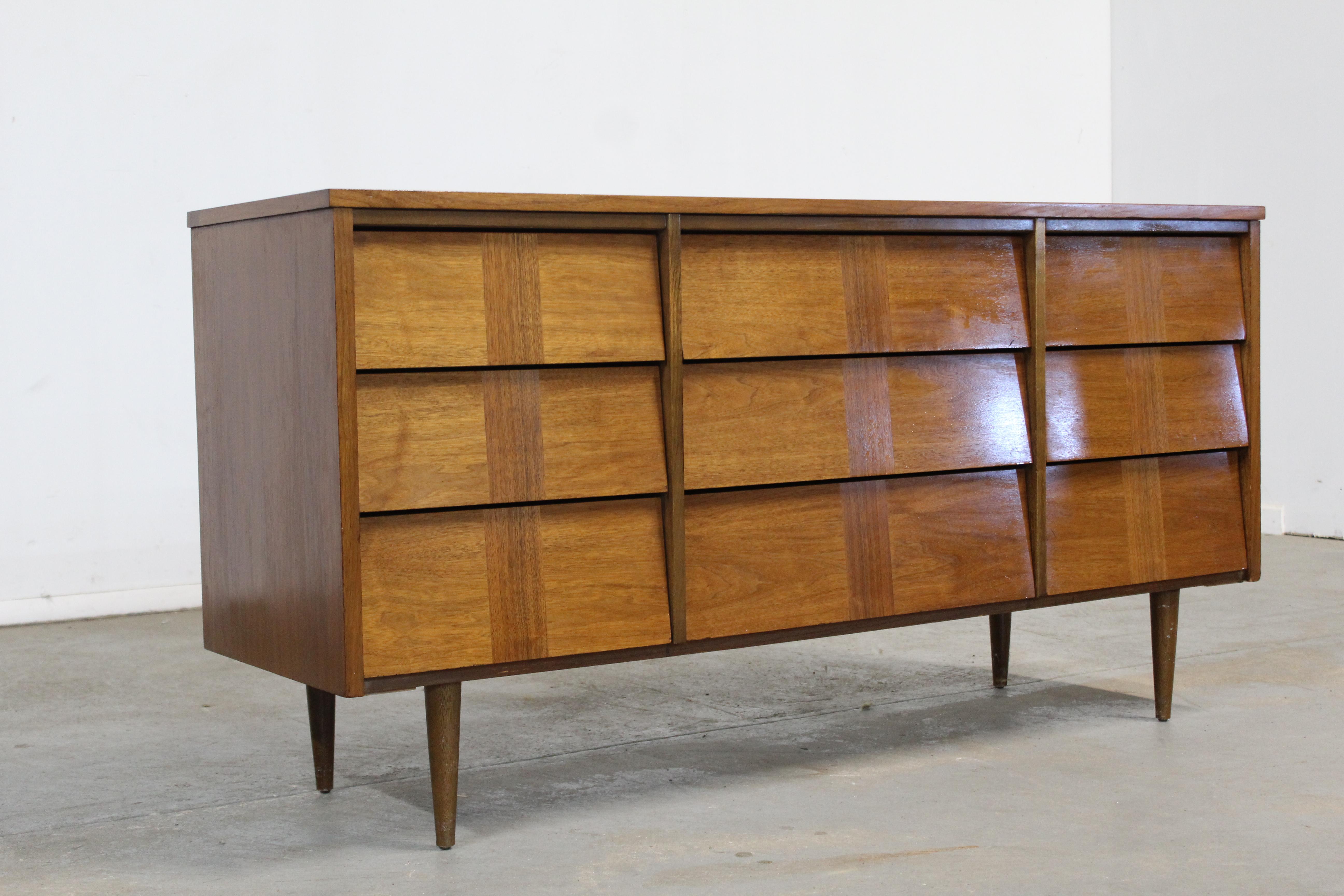 Mid-Century Modern walnut credenza / dresser on pencil legs.
Offered is a beautiful Mid-Century Modern walnut credenza / dresser with ample storage space, by ward Furniture. Features 9 drawers with in laid Walnut. The piece has hidden drawer pulls
