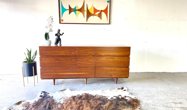 Handsome Mid-Century Modern American of Martinsville long triple dresser. Tons of storage with nine spacious drawers. Danish styling with the superior, 1960s era American craftsmanship. The drawers feature sleek, hardware free facades.The smooth,