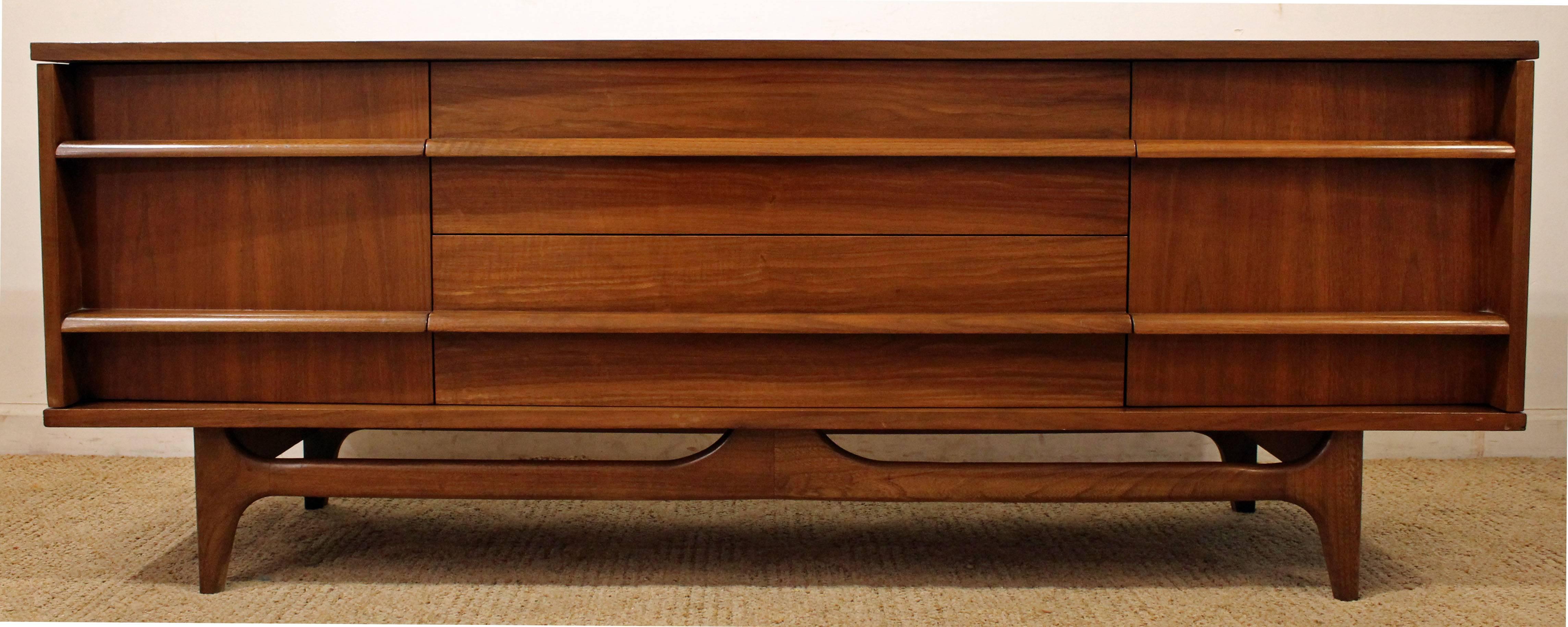 This piece is made of walnut, featuring a curved front, two doors on either side and three center drawers with sculpted pulls. It has been refinished.

Dimensions: 
64