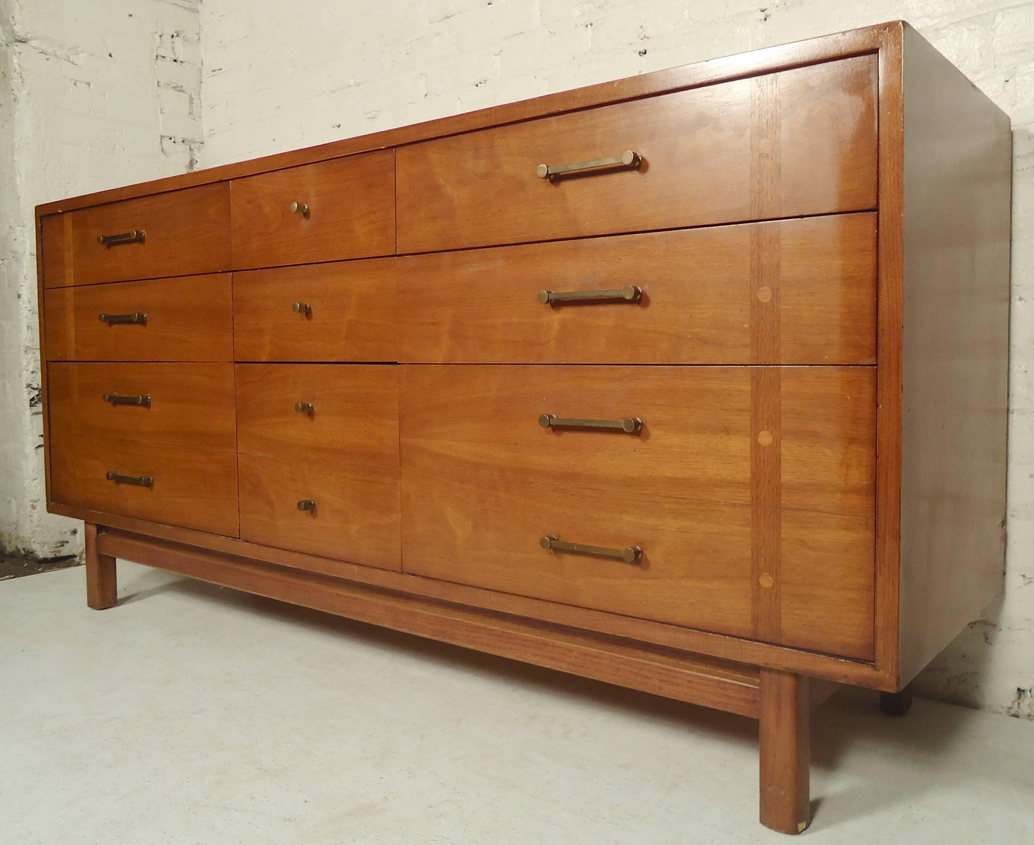 Nine-drawer dresser by Lane with walnut grain. Unique inlay on the front drawers and exposed wood joints.

(Please confirm item location - NY or NJ - with dealer).
 