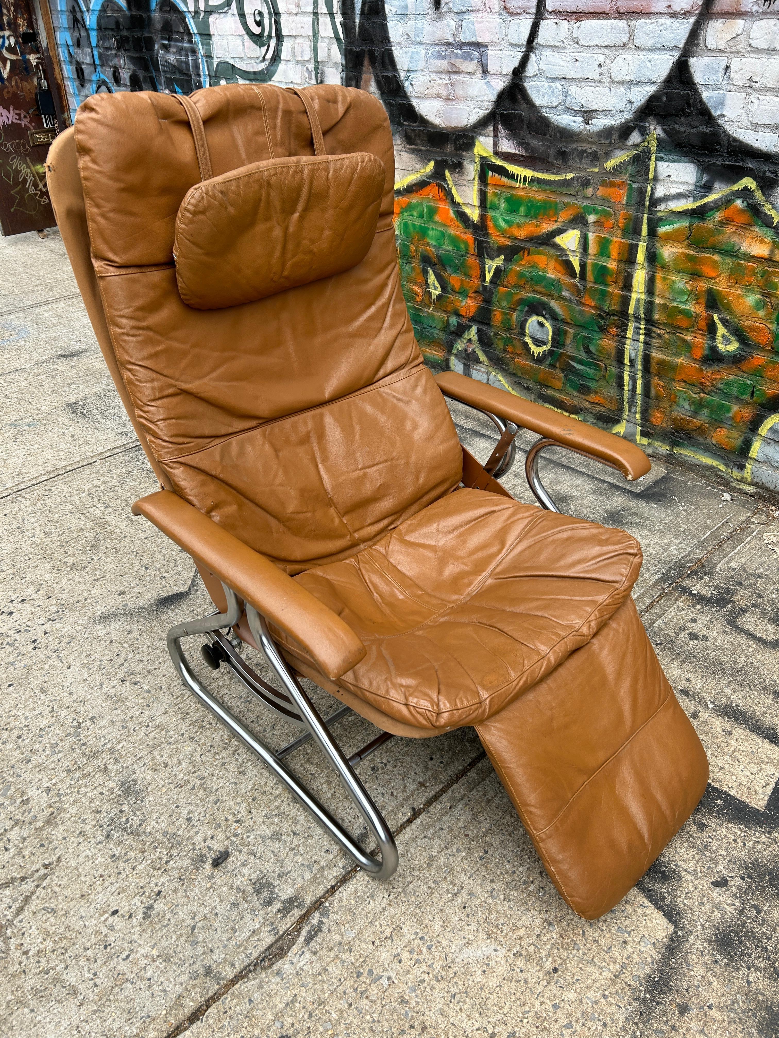 Mid Century Modern Low Leder und Chrom voll Horizontal tilt Hypnosis Lounge Stuhl. Im Stil von Westnofa. Tan Lederpolsterung mit Stoffrückseite auf einem Chromrahmen. Manuell einstellbare Neigung mit schwarzen Kunststoffgewindeschrauben, die in der