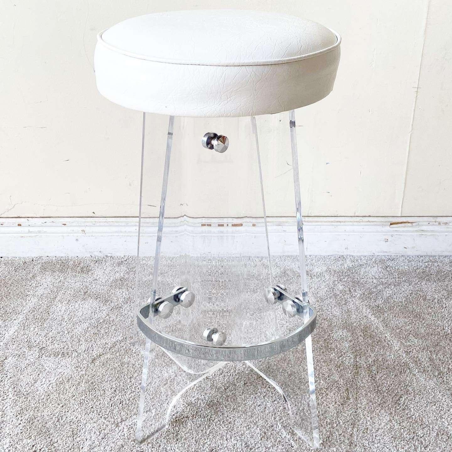 This refined Mid-Century Modern bar stool was made in the United States circa 1970. Features a sculptural scalloped base in translucent lucite with a demilune chrome support.