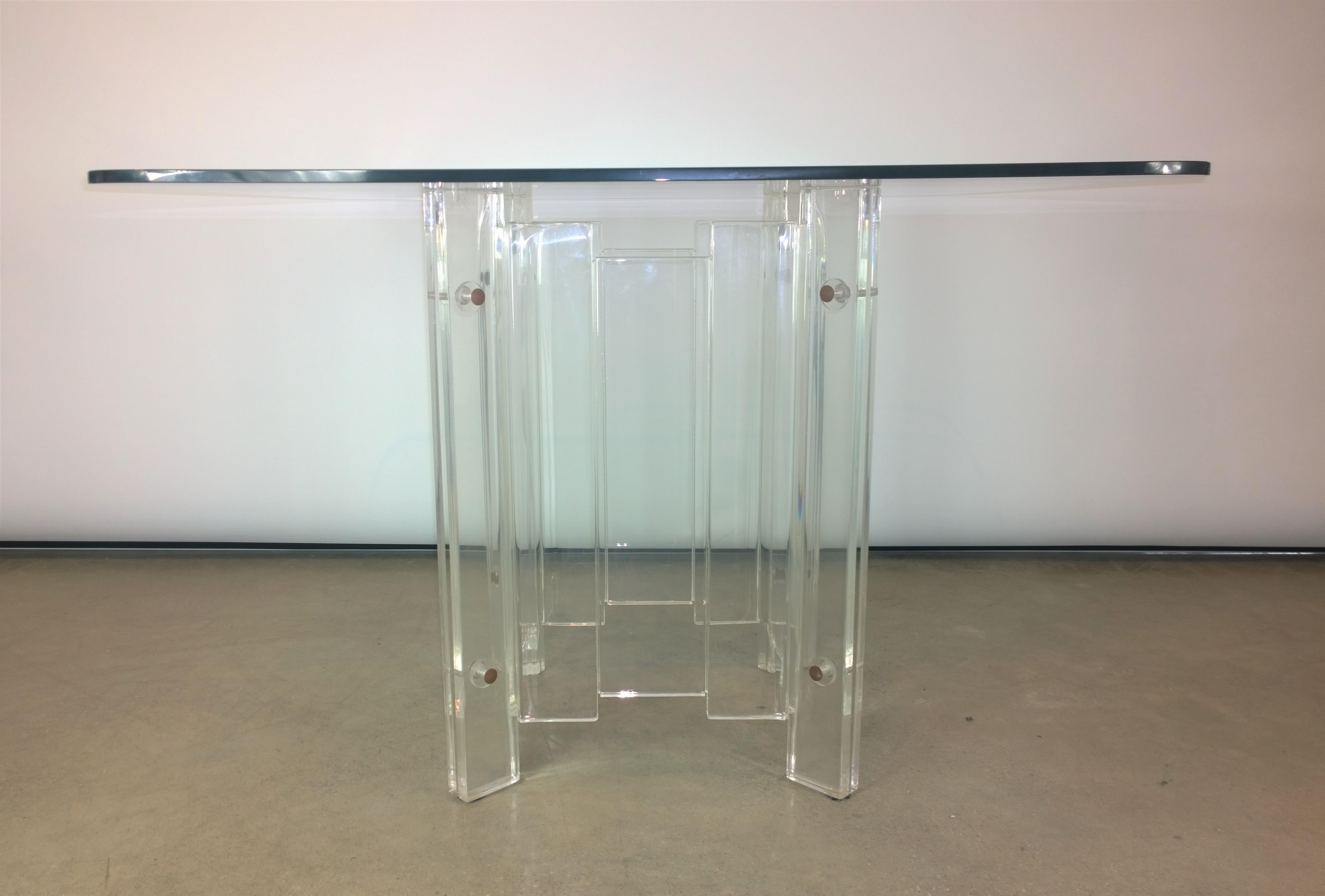 Offered is a Mid-Century Modern Brutalist style Lucite square pedestal and rounded edged square glass top dining, center, game table by Hill Manufacturing. The Lucite base has an Art Deco / Brutalist feel in its design. Hill Manufacturing was one of