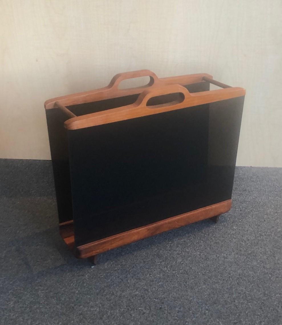 Super rare Mid-Century Modern smoked Lucite and teak magazine rack by Ernest Sohn, circa 1960s. The piece has a sold teak upper and lower portion and smoked Lucite side panels. The double handle makes this a very attractive and functional magazine