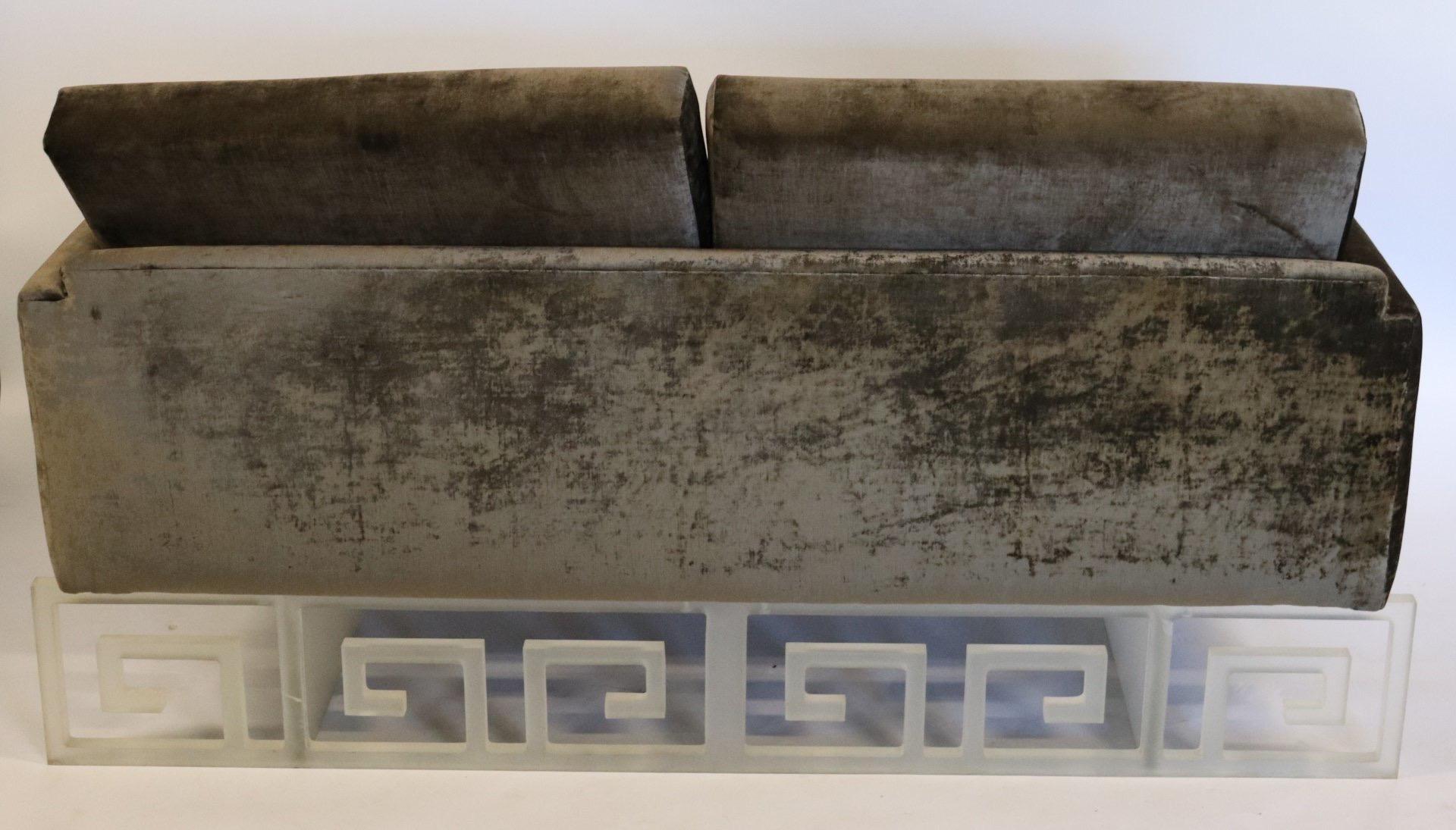 Bespoke loveseat upholstered in a gunmetal crushed velvet and supported by a frosted Lucite base with Greek key pattern on the front and back. Beautiful one-of-a-kind piece!