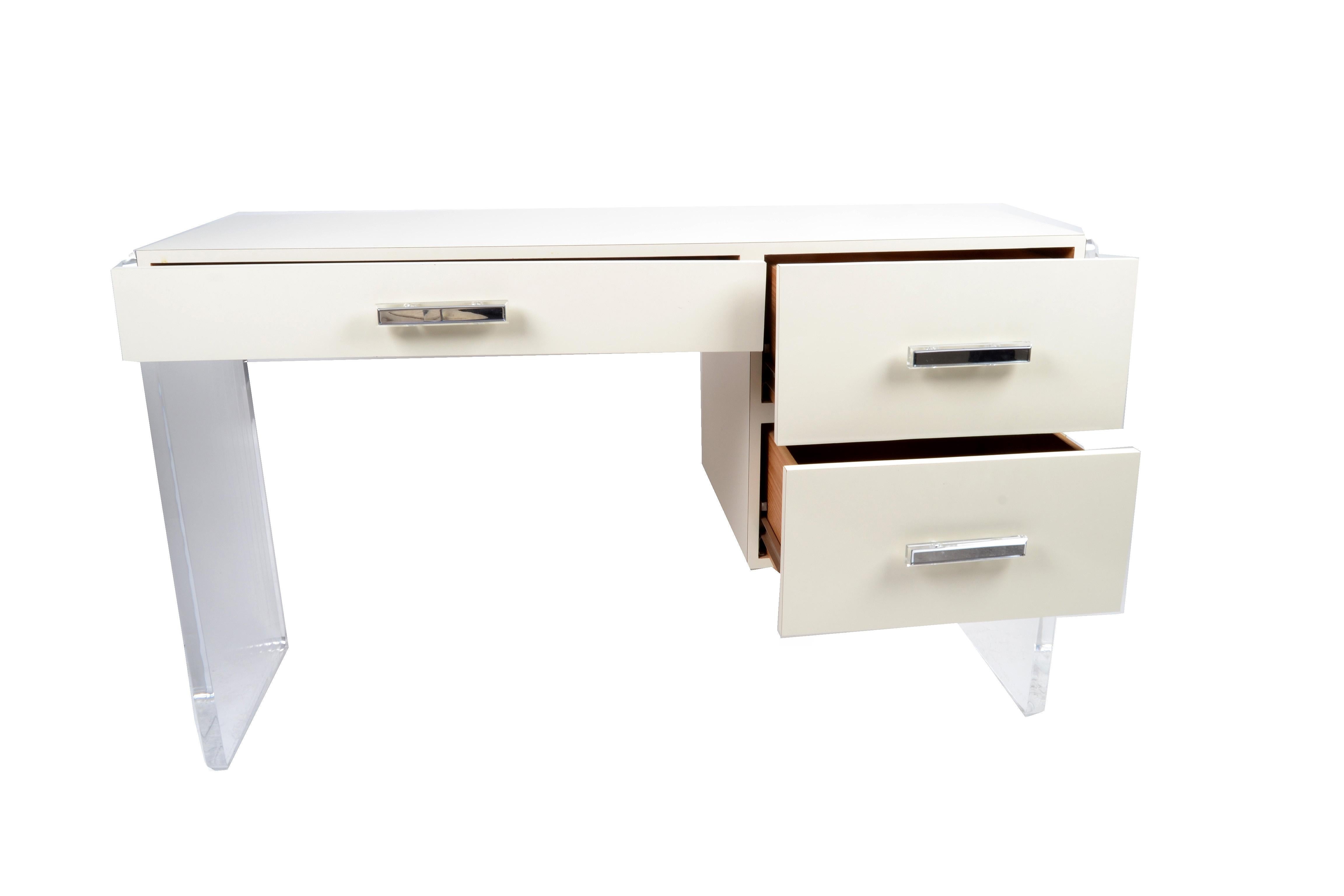 Mid-Century Modern Lucite and wood desk.
The desk features a drawer in the middle and two deeper drawers at the right side.
The handles are mirrored.

