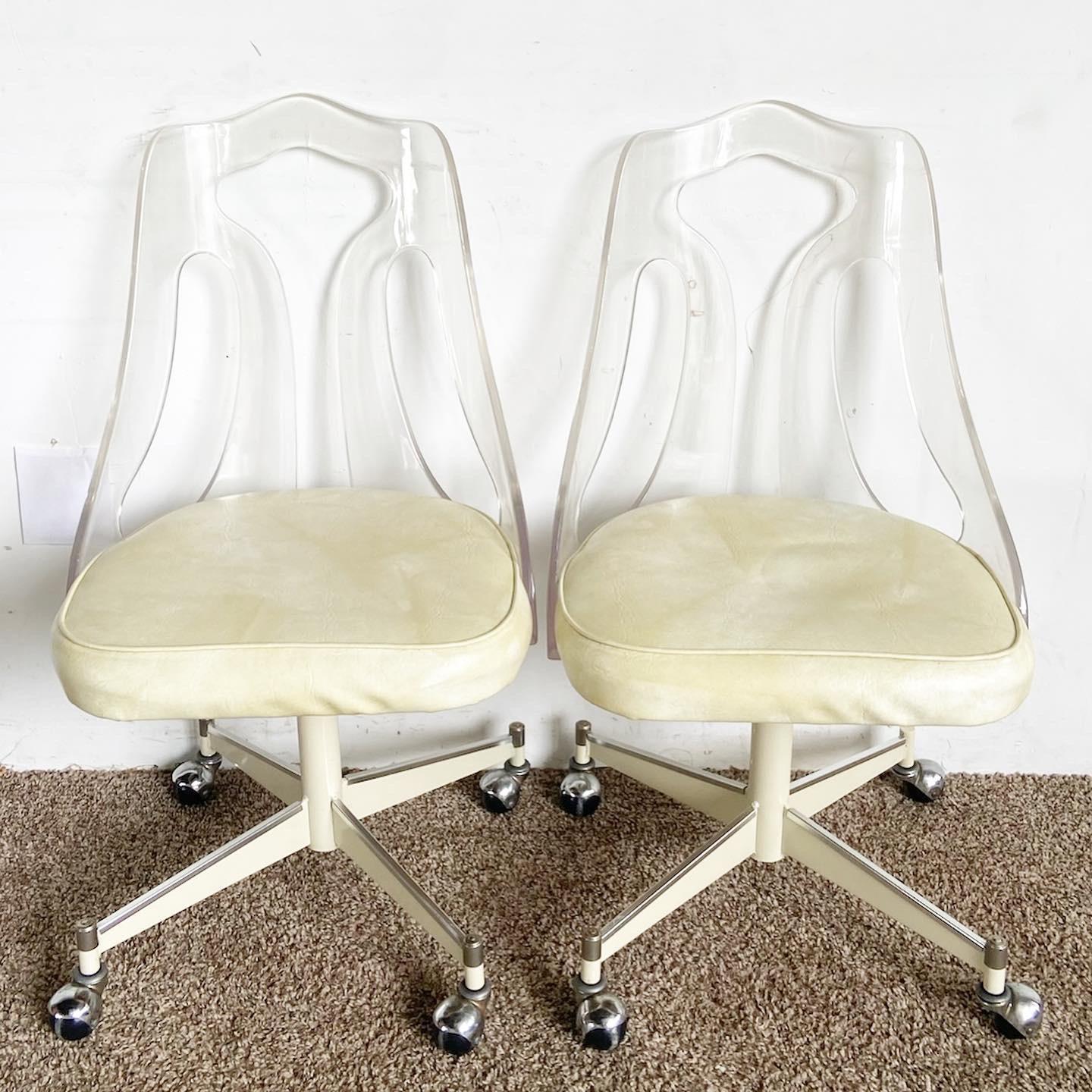 Our set of four Mid Century Modern Lucite Back Cream Cushion and Metal Dining Chairs offers a unique blend of transparent Lucite and plush cream accents.

Features transparent Lucite backs for a unique, modern appeal.
Plush cream cushions provide