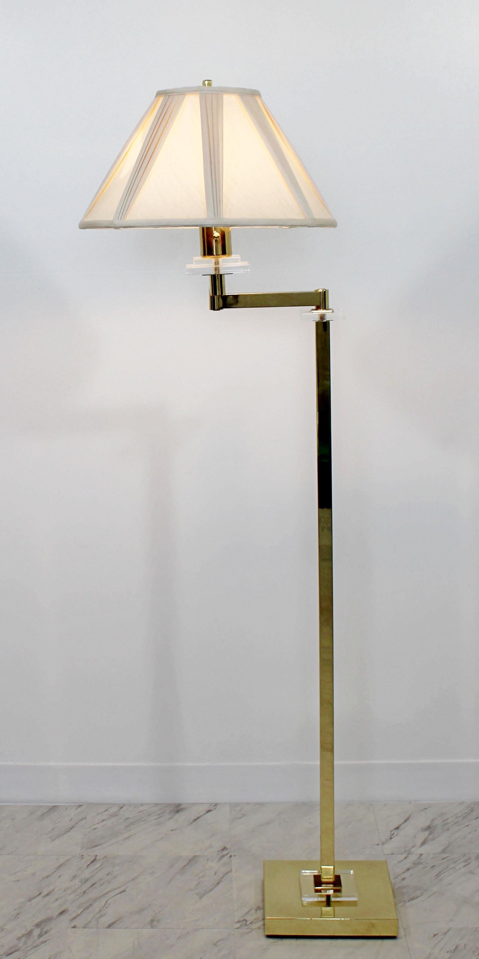 For your consideration is a wonderful, swing arm floor lamp, made of brass and with Lucite accents, with original finial, in the style of Karl Springer, circa the 1970s. In excellent condition. The dimensions of the base are 9.5