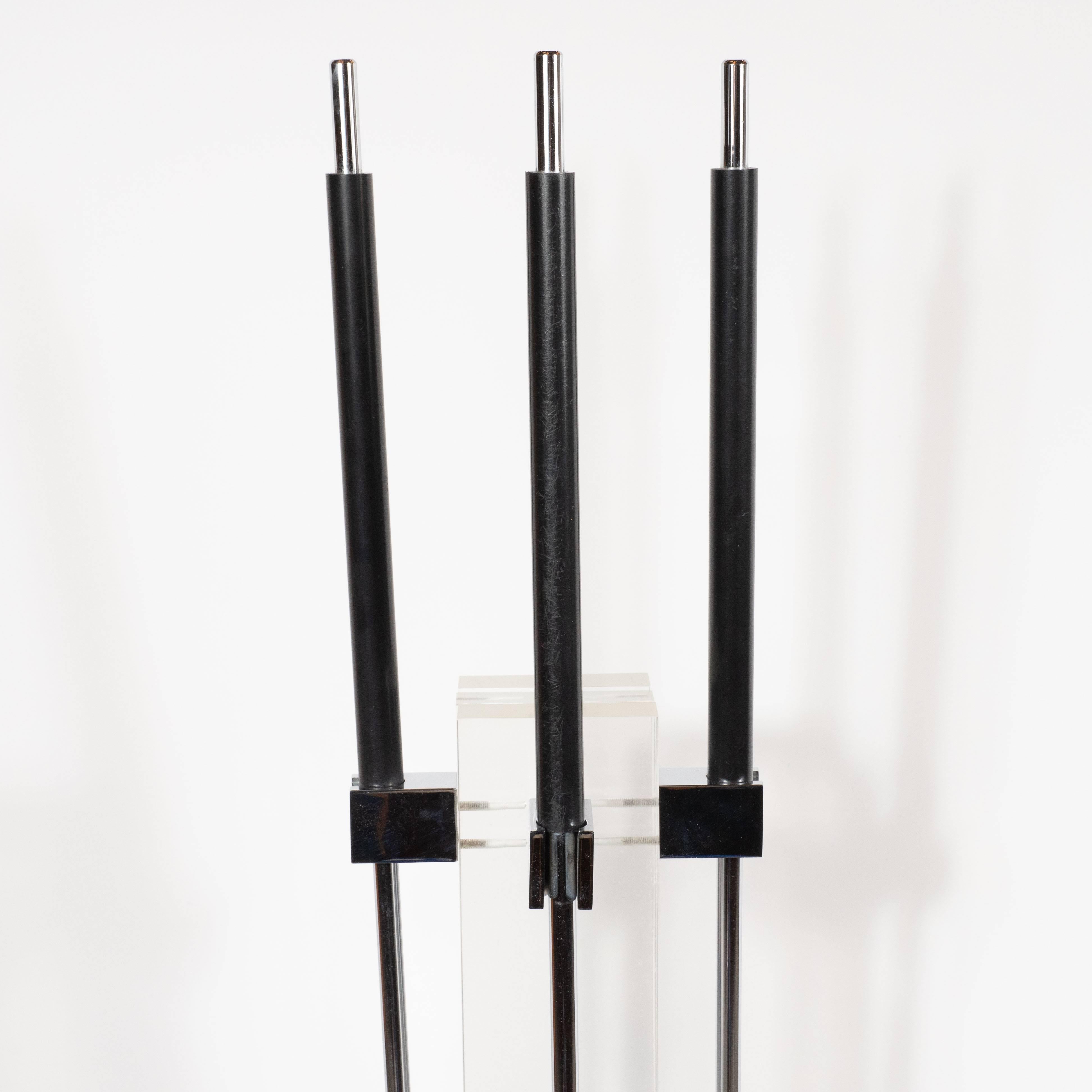 This refined fireplace tool set was realized by the esteemed Mid-Century Modern designer Alessandro Albrizzi, in Italy, circa 1970. The set includes a poker, shovel, brush and stand. The stand is composed of three rectangular slabs of Lucite resting