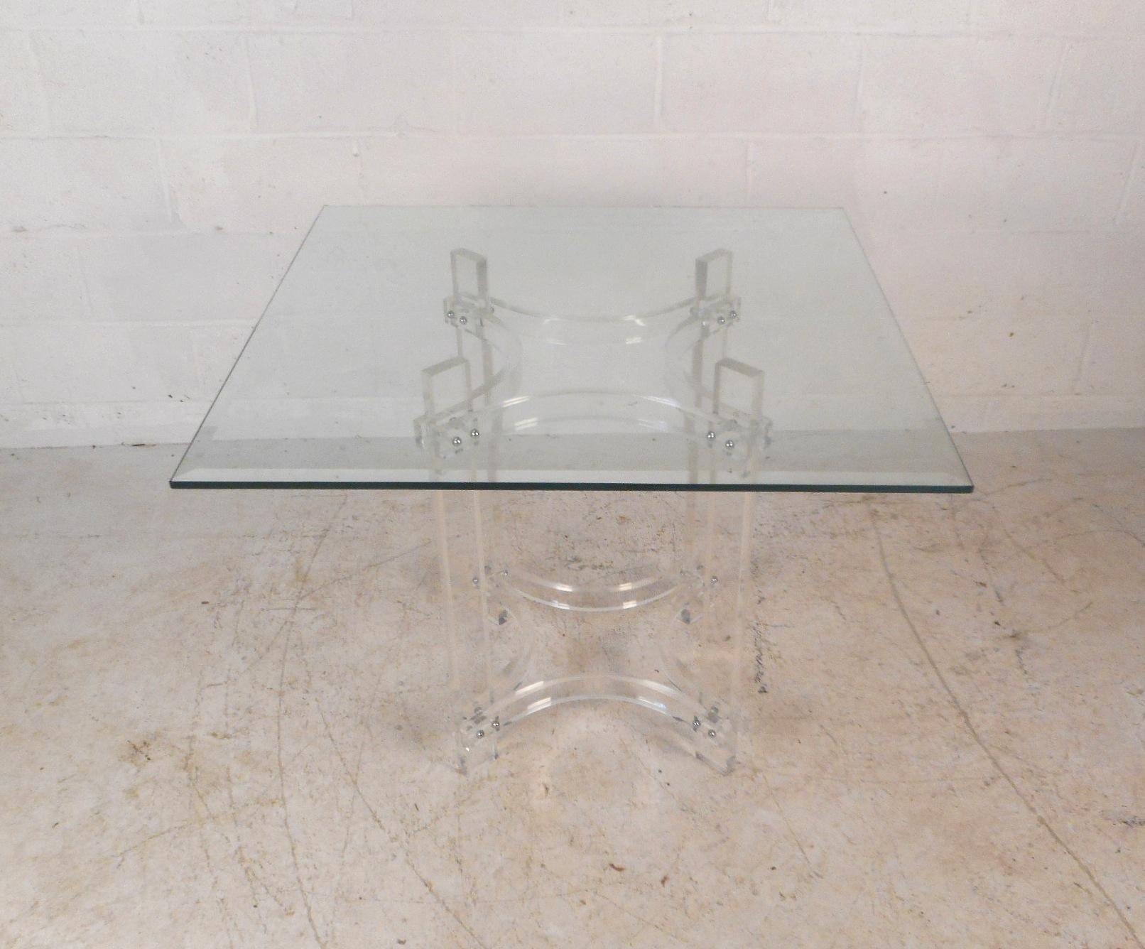 This gorgeous vintage modern dining set includes a Lucite base table with a glass top and four dining chairs. The stylish dining table has a base made entirely of Lucite and a thick square glass top ensuring plenty of room for guests. A lovely set