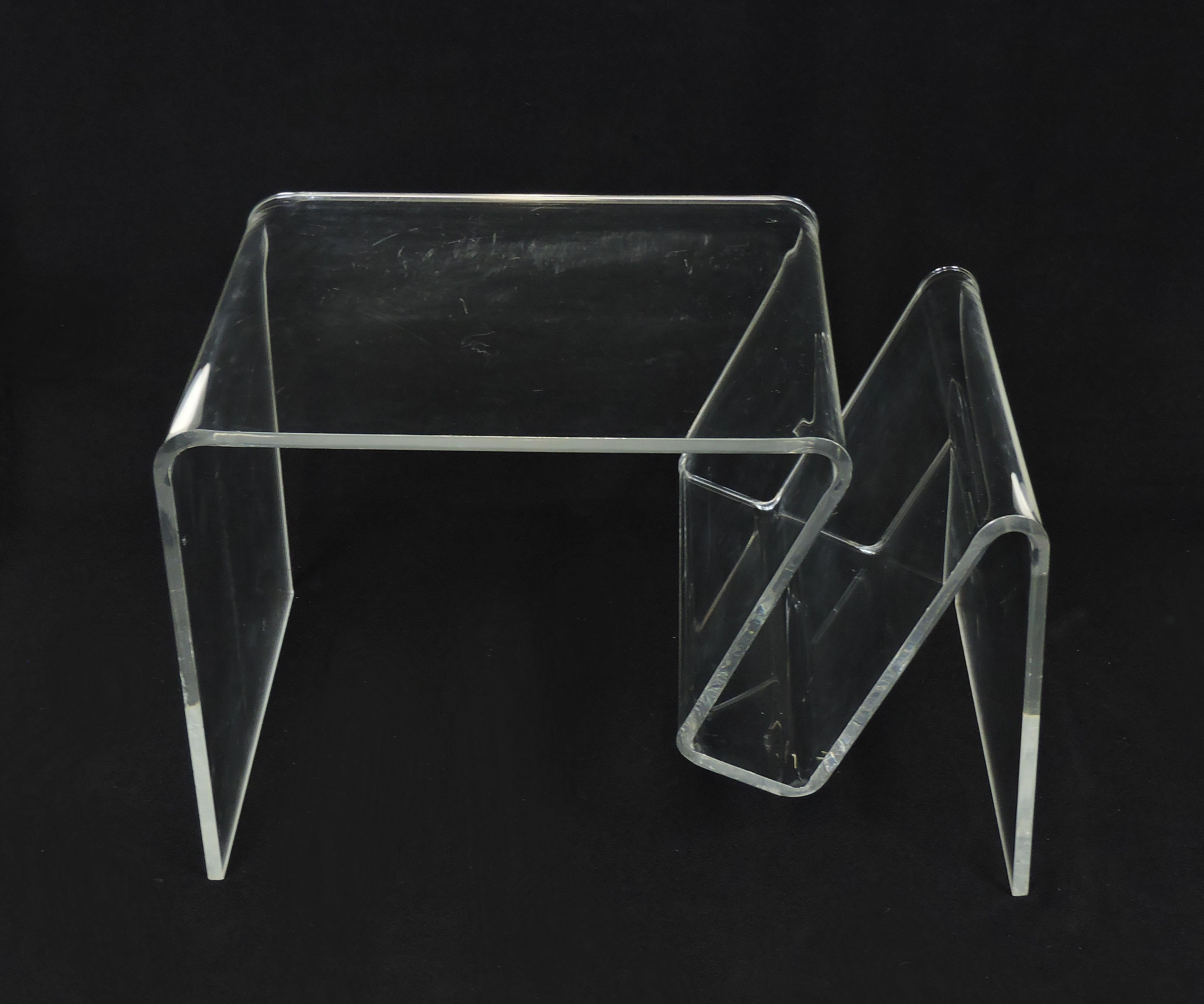 Beautiful and practical clear Lucite end table that also has a place to hold magazines. This table is formed from one continuous piece of half-inch thick molded clear Lucite. A very similar design by Andrew Ivar Morrison is in the collection of the