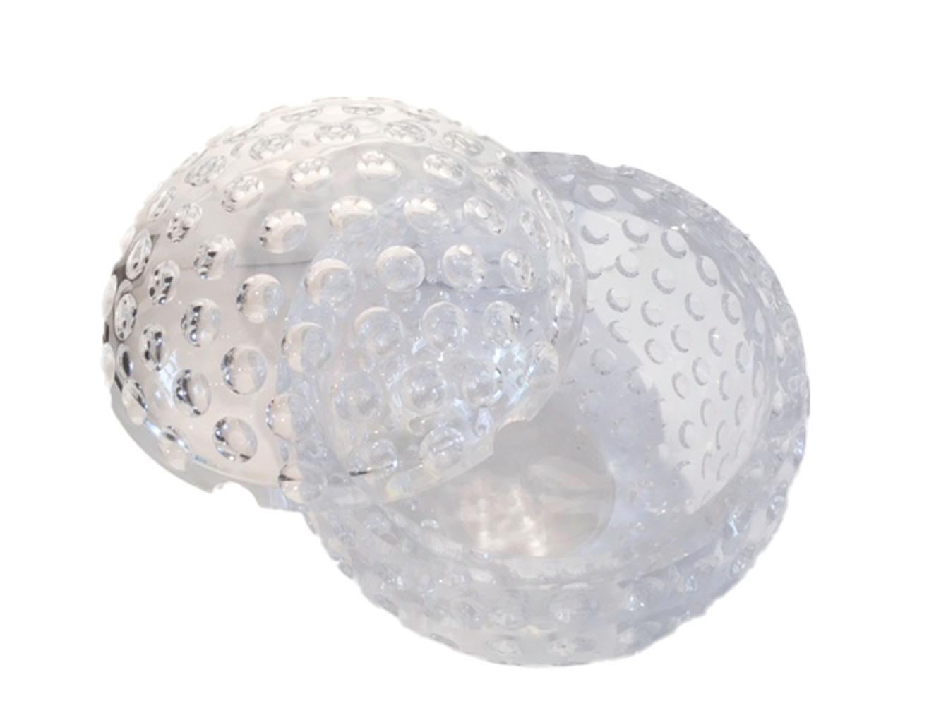 Vintage Lucite ice bucket of spherical form with a pivoting top. The entire surface covered with golf ball-like divots, each of which reflects the others creating an optical effect.