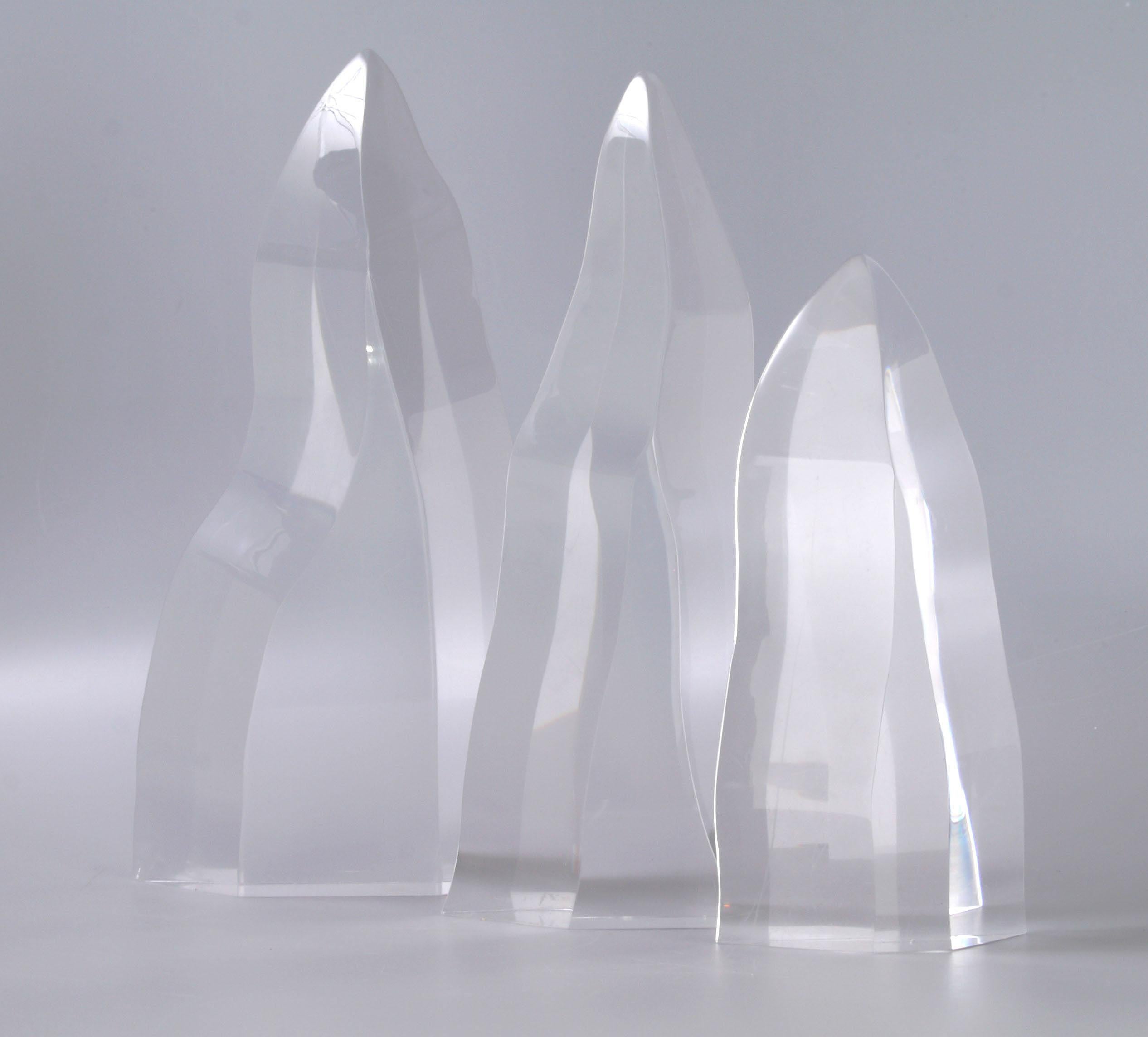 Set of three Mid-Century Modern Lucite iceberg sculptures in graduated sizes. 
Large, 7.25 inches L x 2 inches W x 14.5 inches H. 
Medium, 6.5 inches L x 2 inches W x 13.5 inches H. 
Small, 4.75 inches L x 2 inches W x 10 inches H. 
Recently