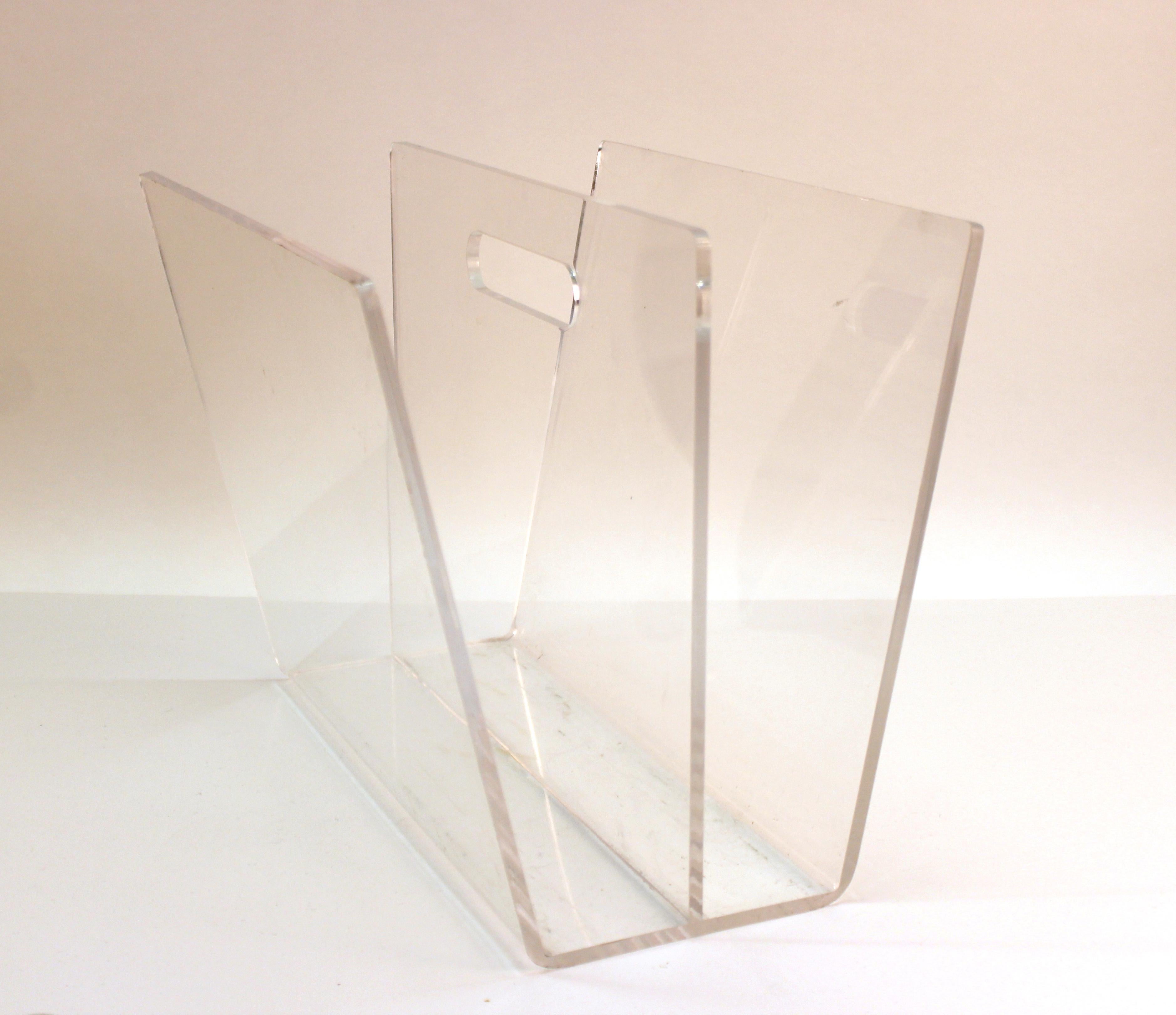 Mid-Century Modern magazine rack in clear Lucite. The piece dates from the 1970s and is in great vintage condition with some age-appropriate wear and minor scratches to the surfaces.