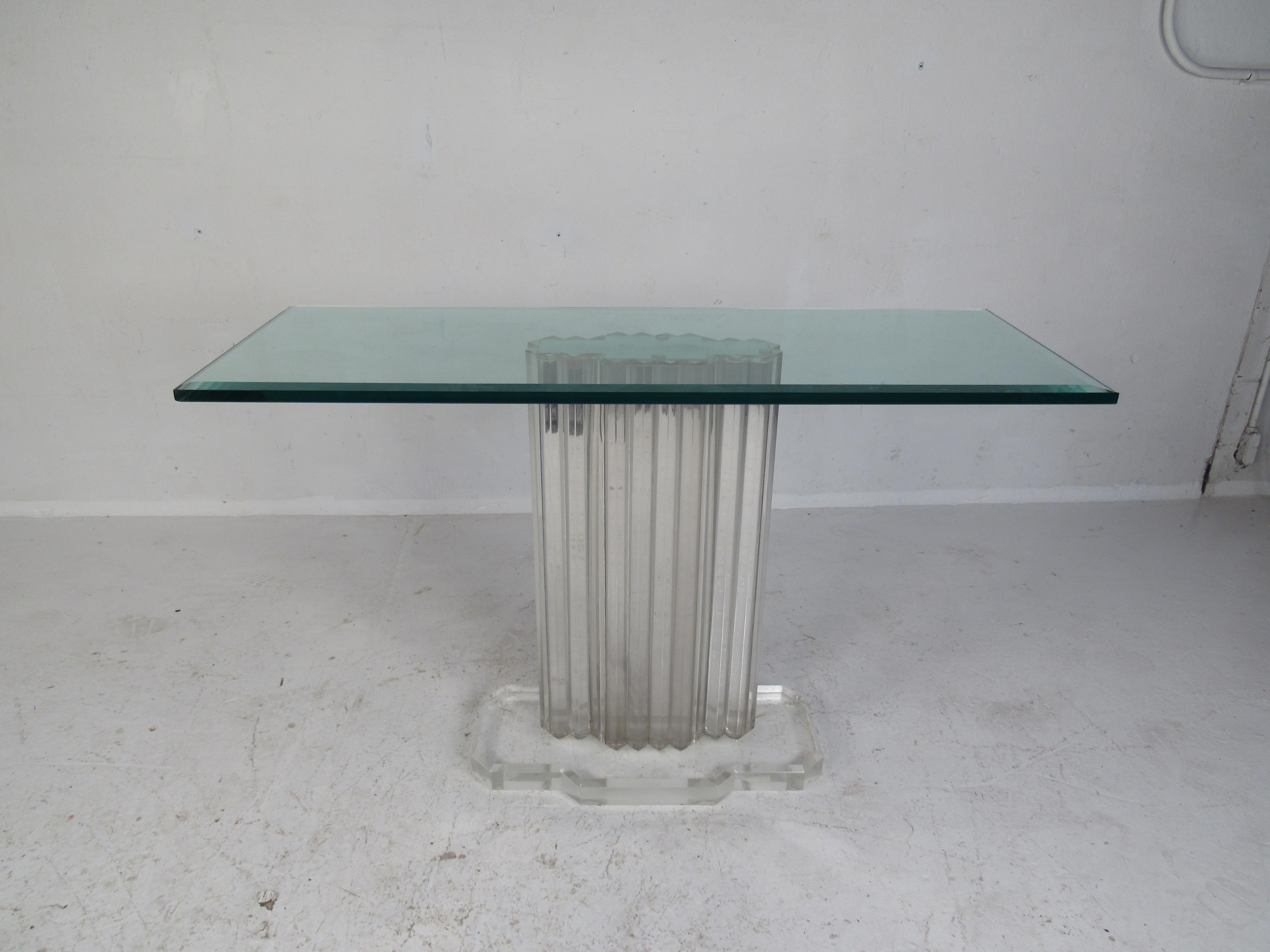 A stunning vintage modern hall table with an unusual Lucite pedestal base and a thick rectangular glass top. This beautiful console boasts a sculpted mirror on the top of the multifaceted acrylic base. This sleek midcentury table looks amazing in