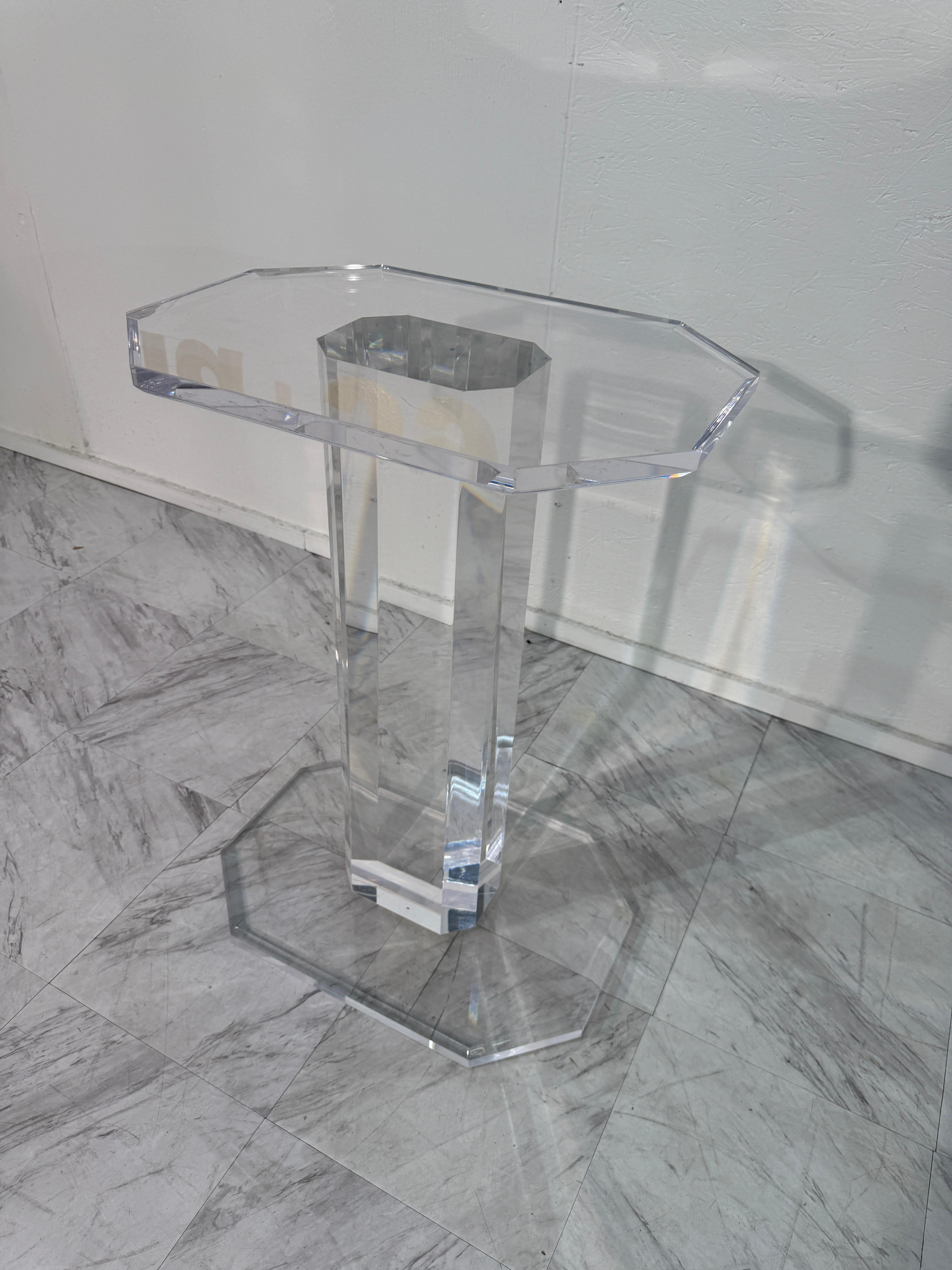Un sorprendente tavolo con piedistallo della metà del secolo scorso realizzato interamente in lucite trasparente, con un piano ottagonale sfaccettato e una base collegata da una solida colonna in lucite. La trasparenza del materiale crea un effetto