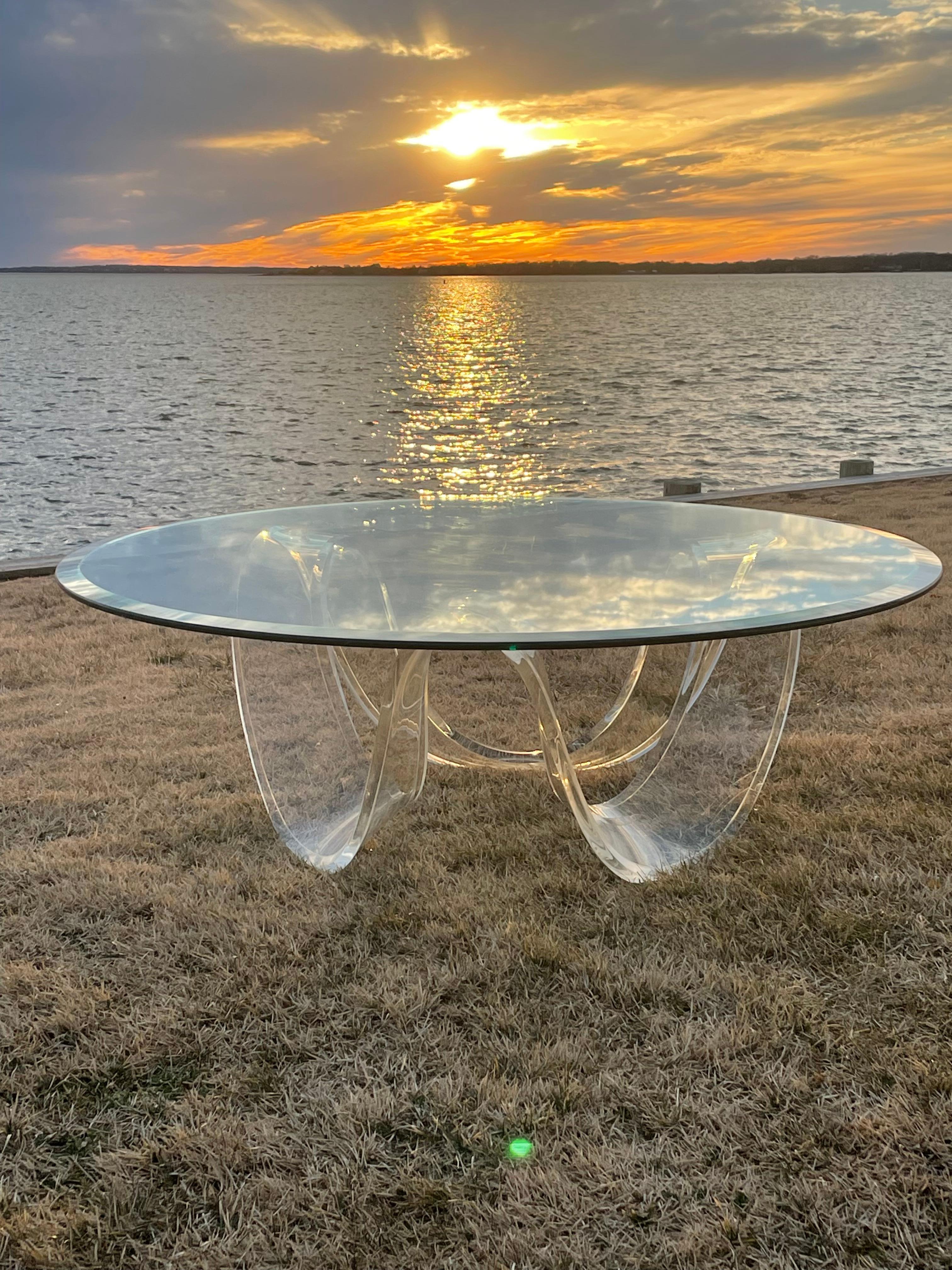 Mid Century Modern lucite ribbon coffee table . Sexy sculptural base that arches up and down in a continuous wave loop . The glass top has a beveled edge .Great modern design for any decor .Very good Condition .
Glass Top is 44” Diameter
Lucite Base