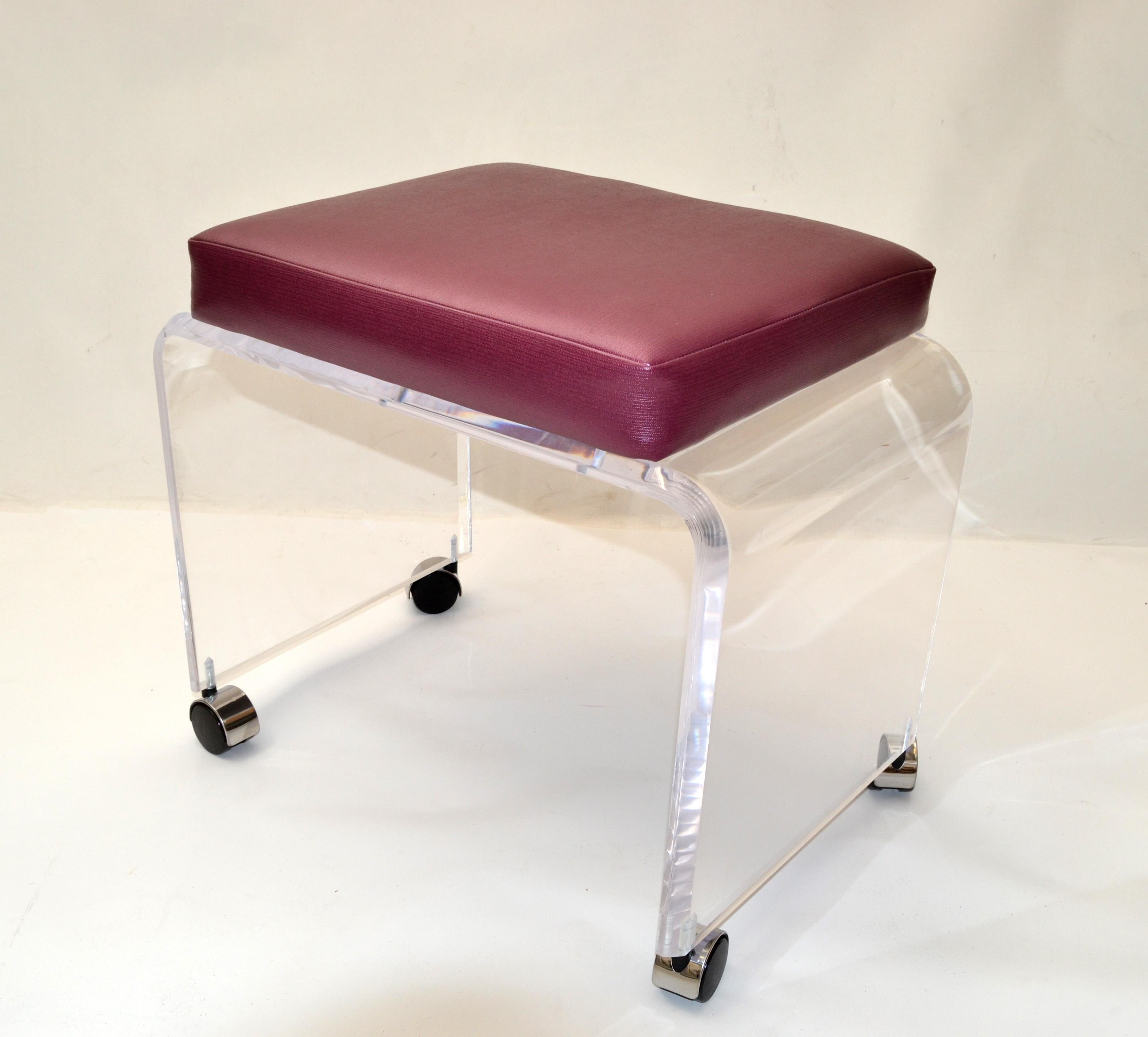 Mid-Century Modern Lucite stool with dark Magenta patent leather seat upholstery on Chrome casters.
This stool can be used as a footstool, vanity stool, bench or a place to put your magazine.
The stool is firm and sturdy, ready for a new home.
  