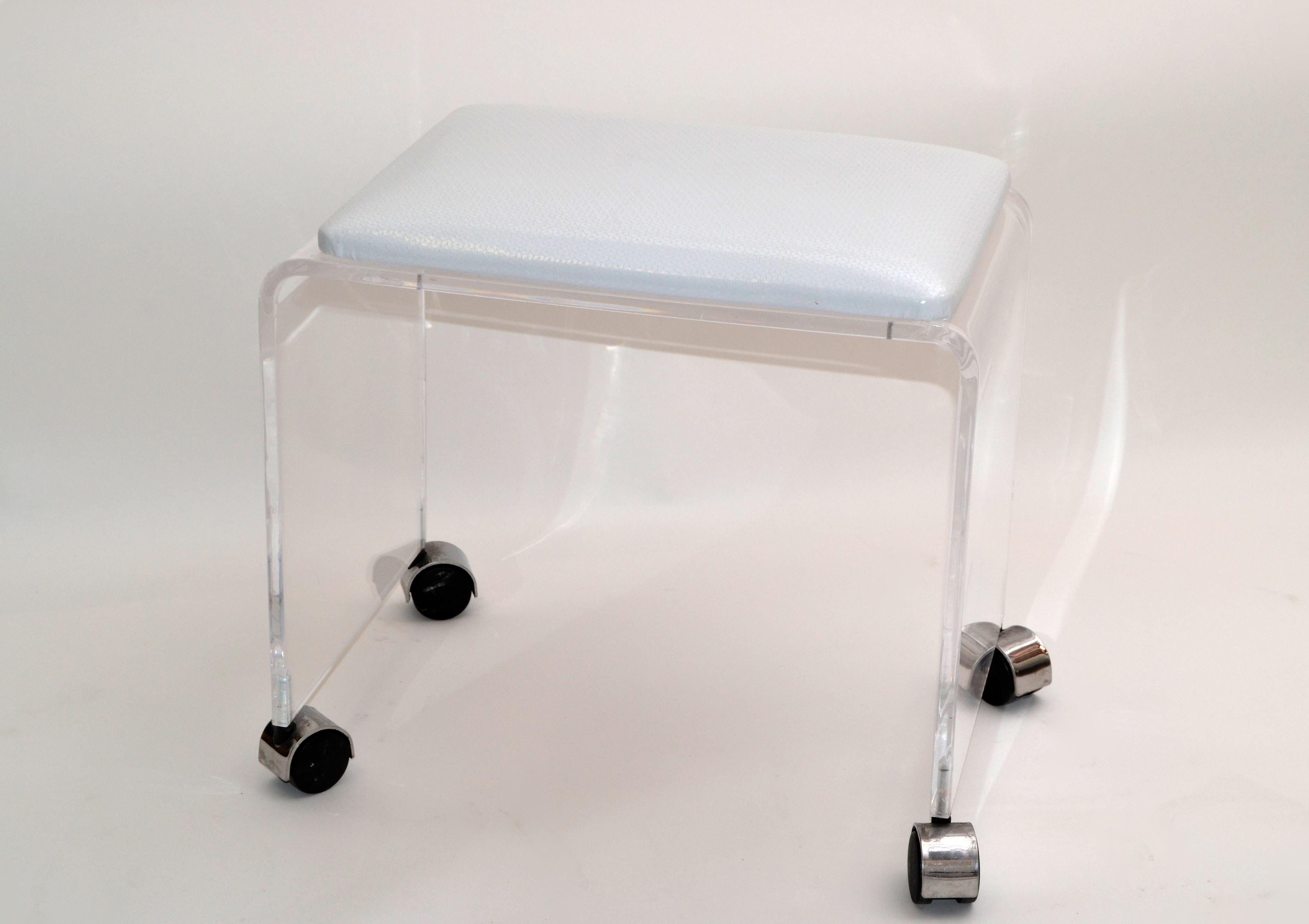 Mid-Century Modern Lucite stool with white vinyl seat on chrome casters.
This stool can be used as a footstool, vanity stool or a place to put your magazine.
The stool is firm and sturdy, ready for a new home.
  