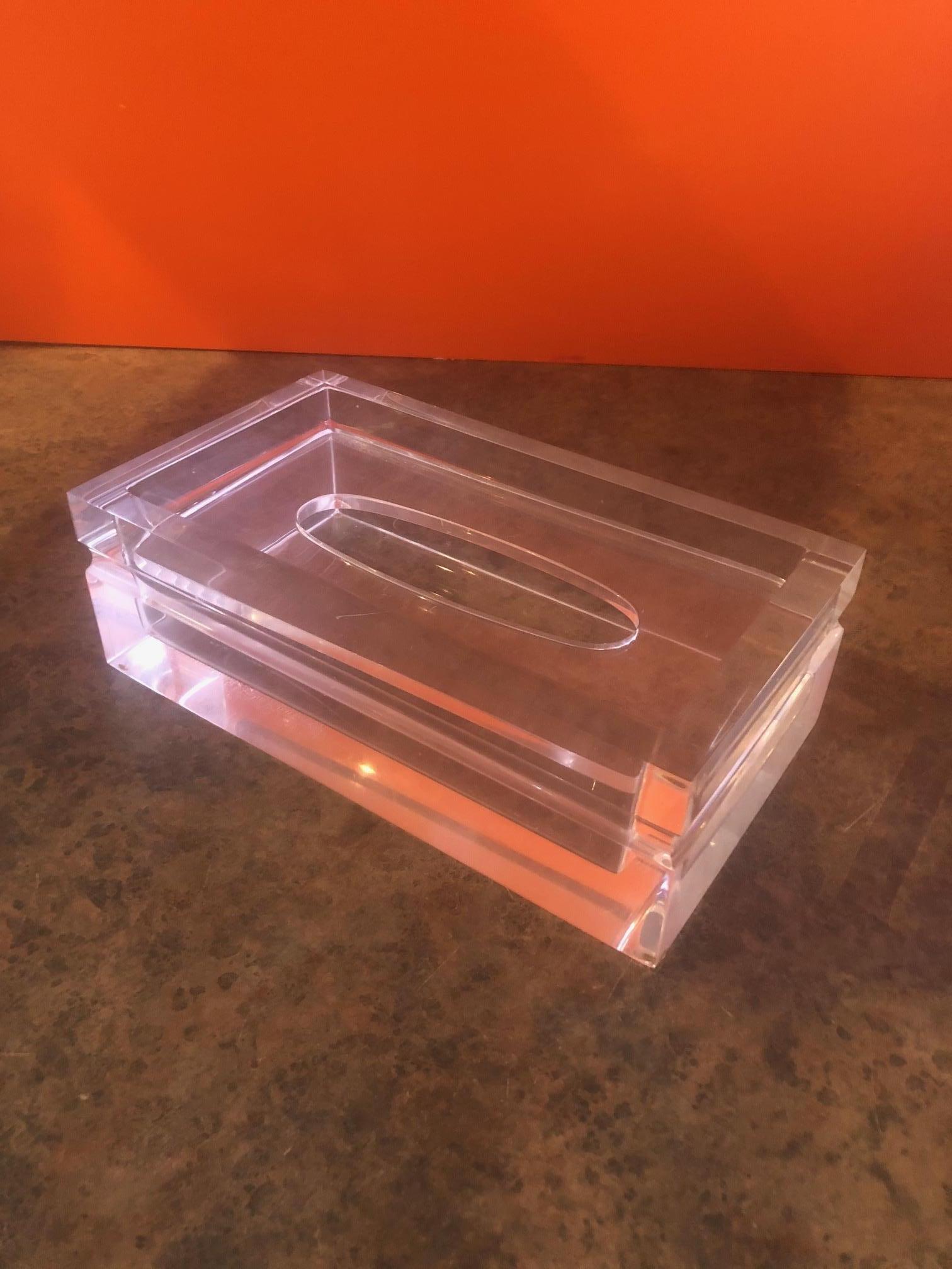 Mid-Century Modern Lucite tissue box in the style of Charles Hollis Jones, circa 1970s. The piece is very heavy and substantial with a horizontal groove around the sides. The top plate is removable to restock tissues. Very cool piece!  #922