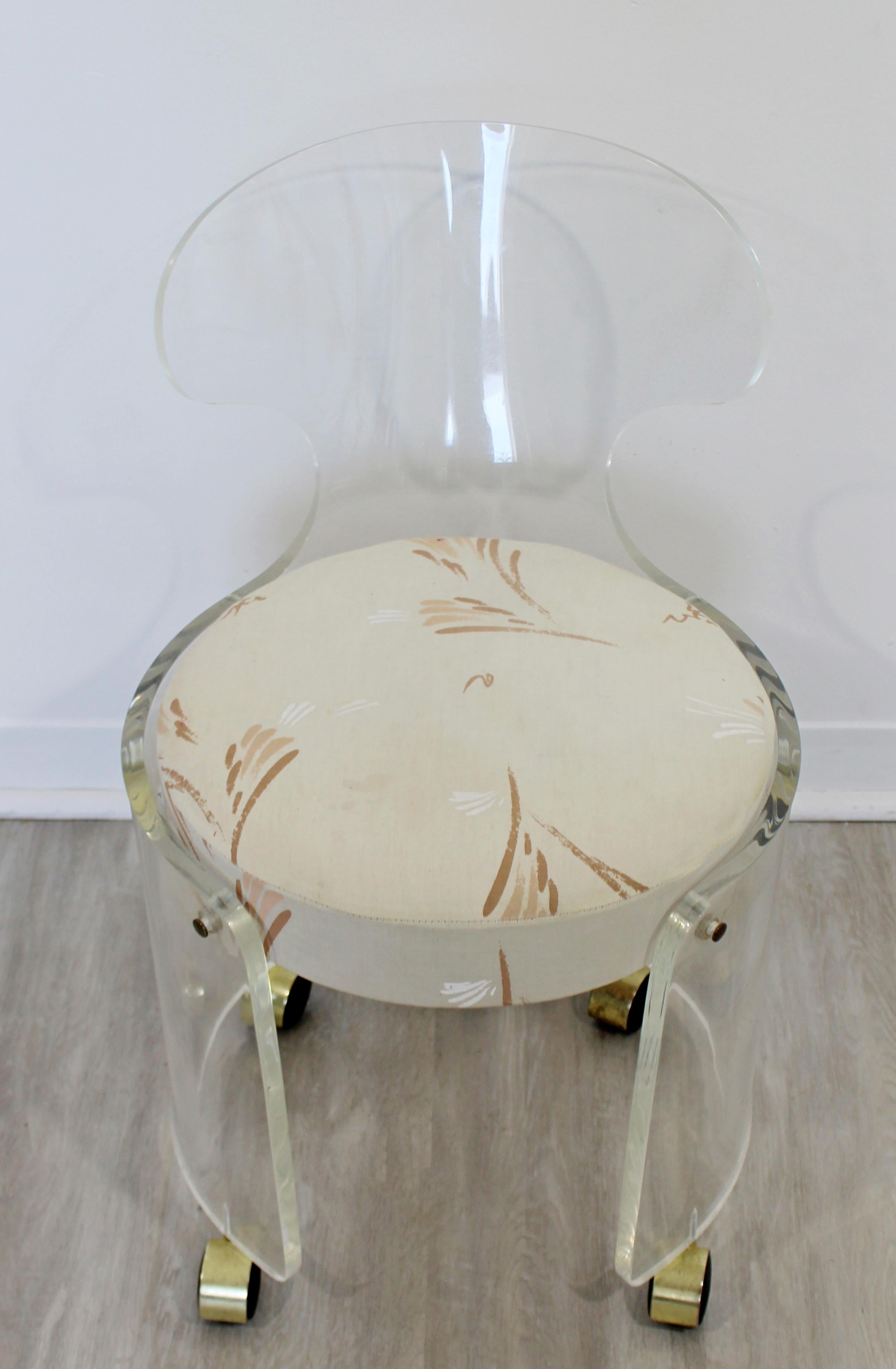 For your consideration is a sweet, Lucite rolling vanity chair, with an original Hill Manufacturing tag, circa 1960s. In excellent vintage condition. The seat could be reupholstered. The dimensions are 16.5