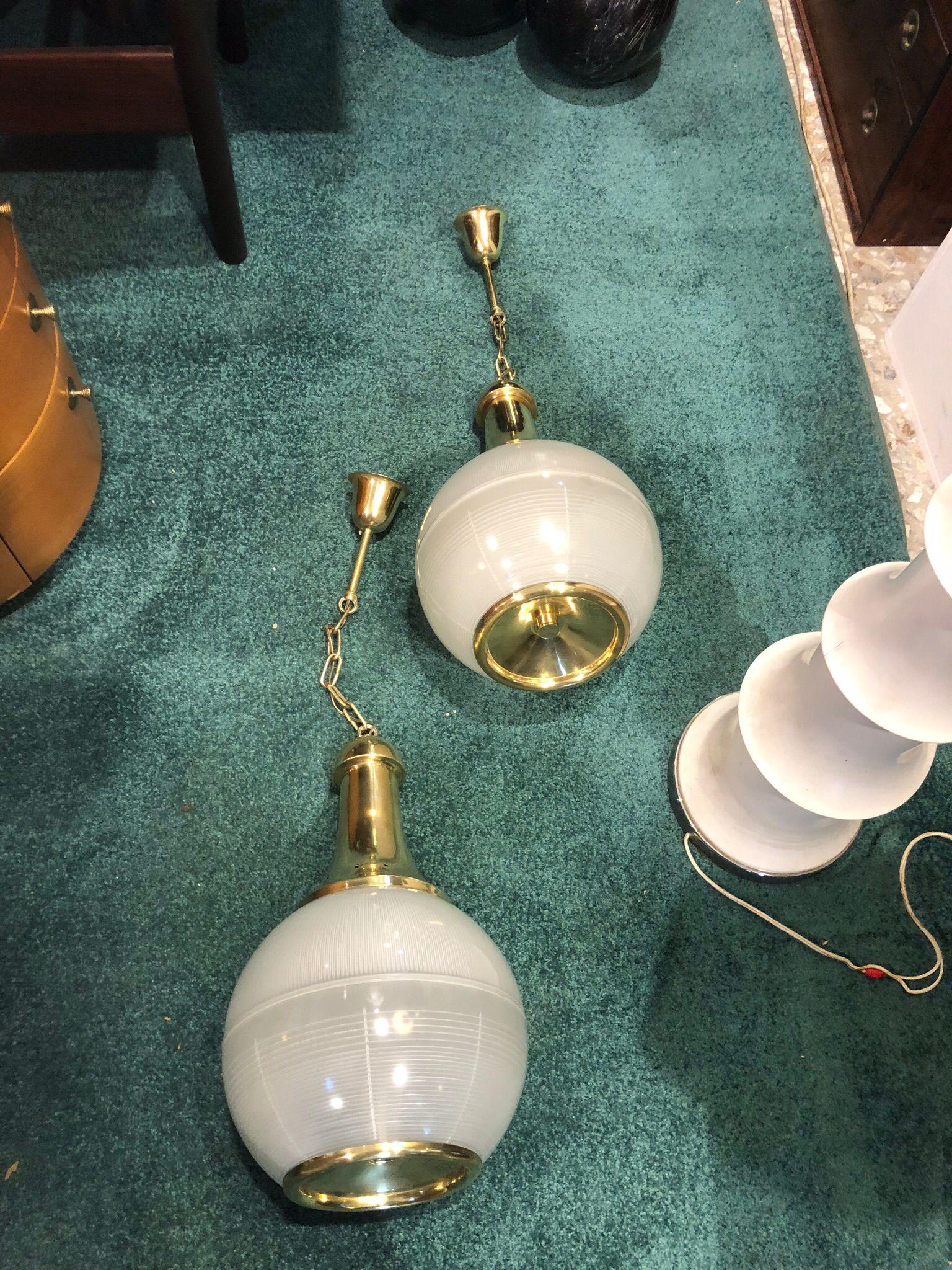 Charming Italian Mid-Century-Modern, Pair of pendant lamps designed by Luigi Caccia Dominioni for the Azucena fashion house in the 1950s.
Model, made of satin blown glass and structure in polished brass. Excellent conditions. Dimensions of the