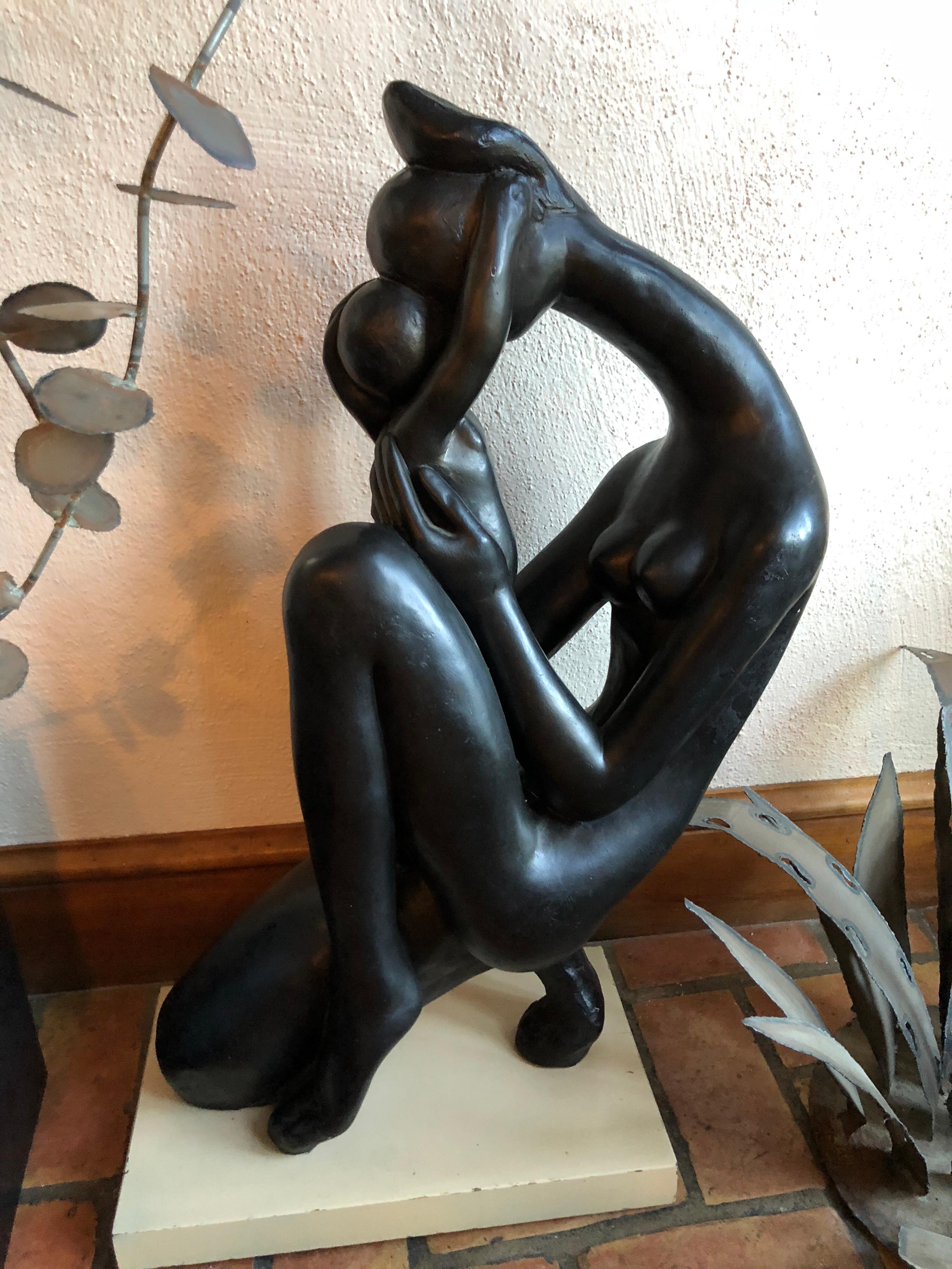 Mid-Century Modern Madonna and Child sculpture. Black figural of mother and child in a dark metal with lacquered finish. Ivory wooden base. Please request a parcel shipping quote which may be more economical than white glove.