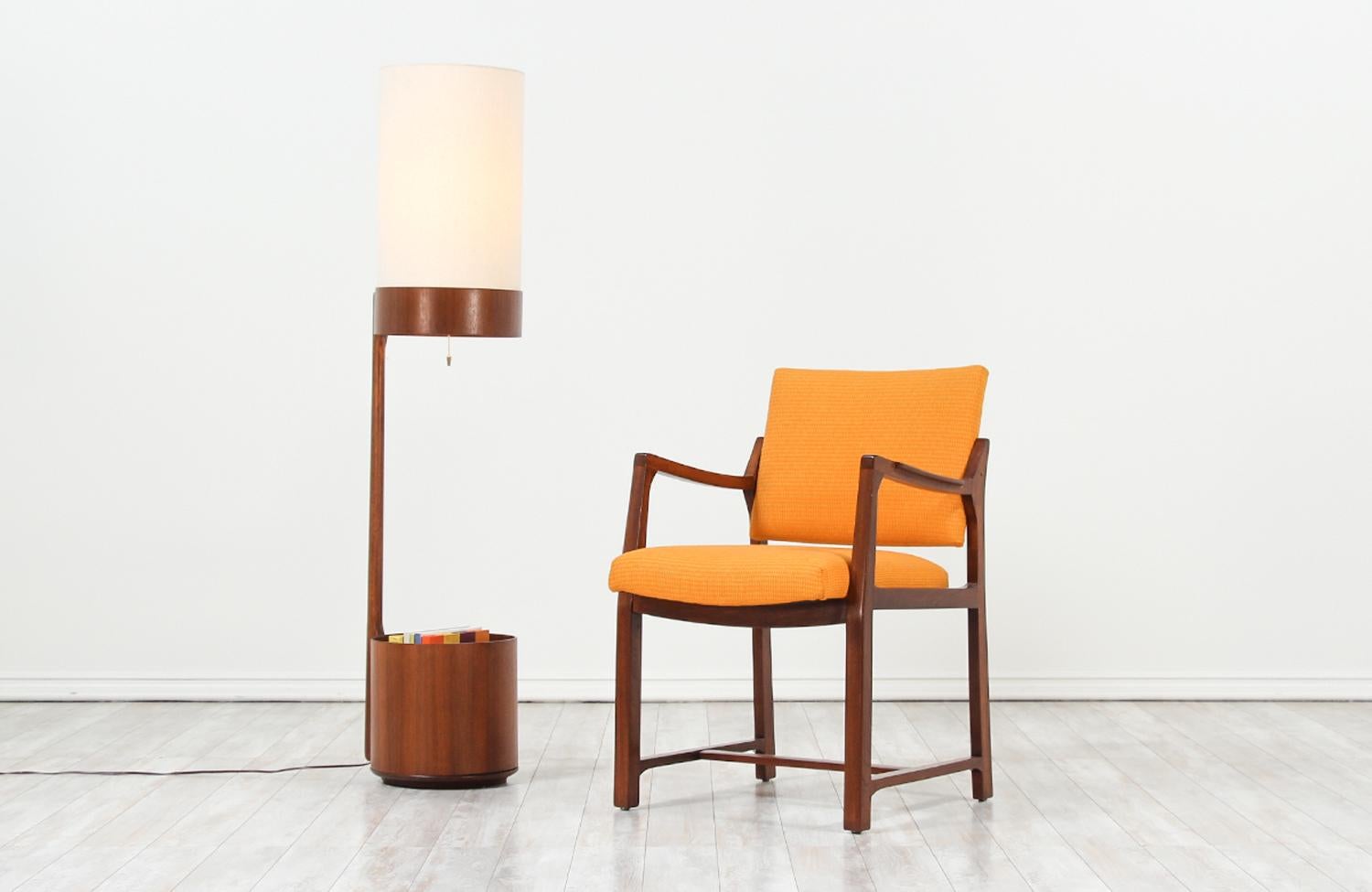 Stylish modern floor lamp designed and manufactured by Modeline of California in the United States circa 1960s. This gorgeous and multifunctional floor lamp is crafted from walnut wood featuring a tall body and a lower magazine storage space. This
