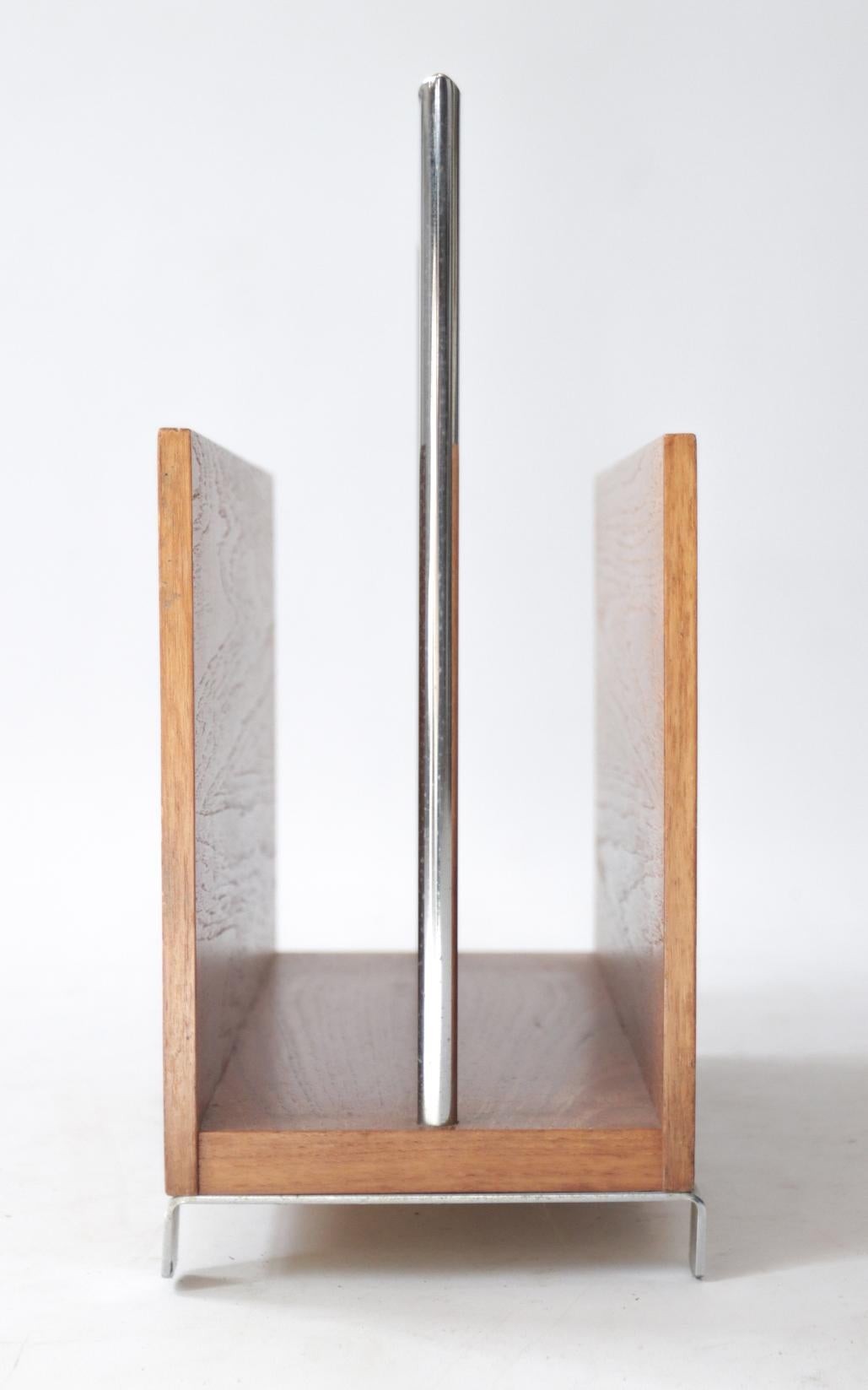 Sleek magazine rack made of teak (veneer) and chrome-plated metal from the 1960s.

The chrome has some small spots, the teak veneer is in a very nice condition considering its age.