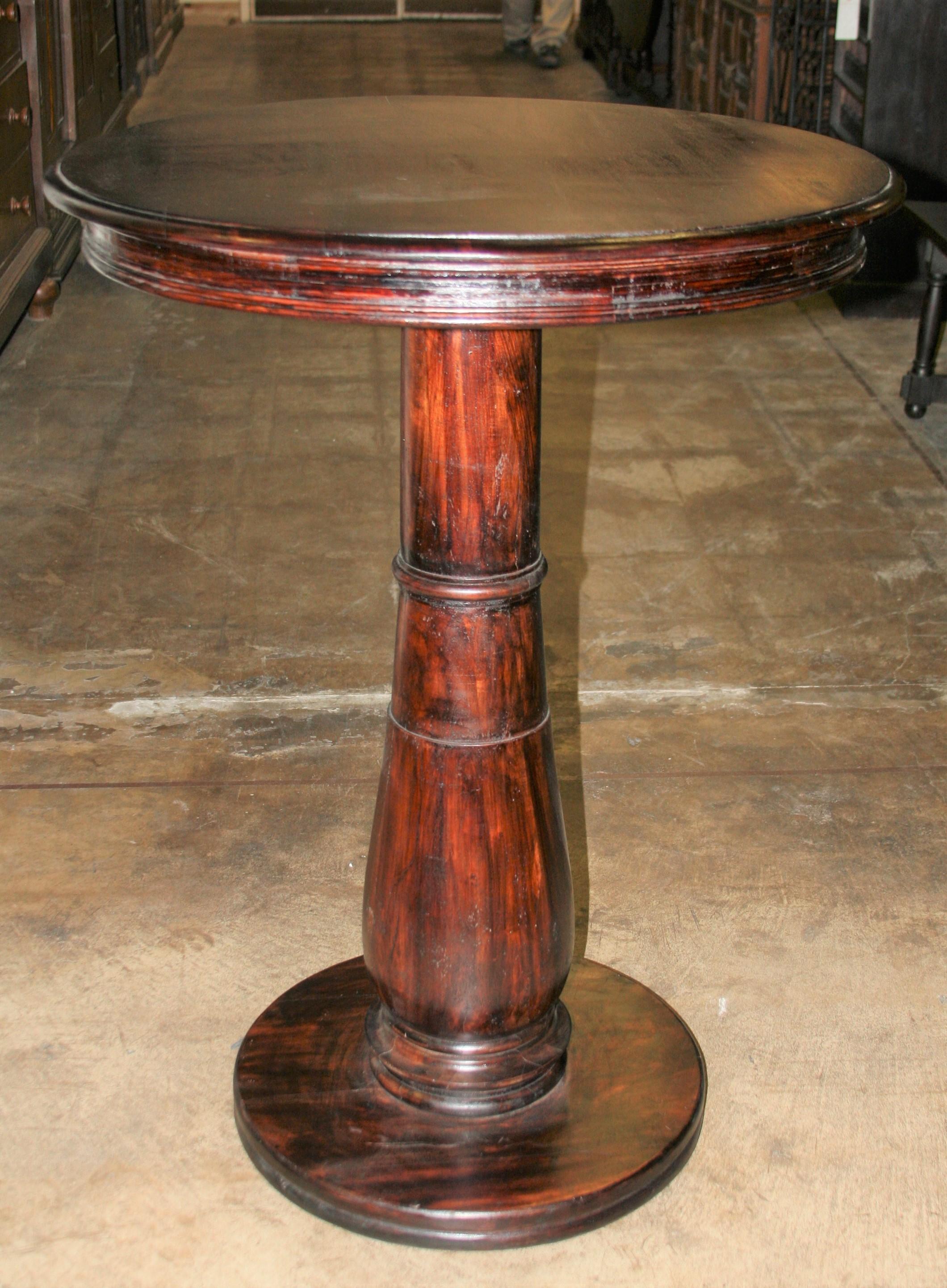 Simple but elegant mahogany breakfast bar table for luxury penthouses. The round top is held by a robust solid wooden columnar support on a solid wood round base. This table will make a statement in any opulent setting. Will last several decades.