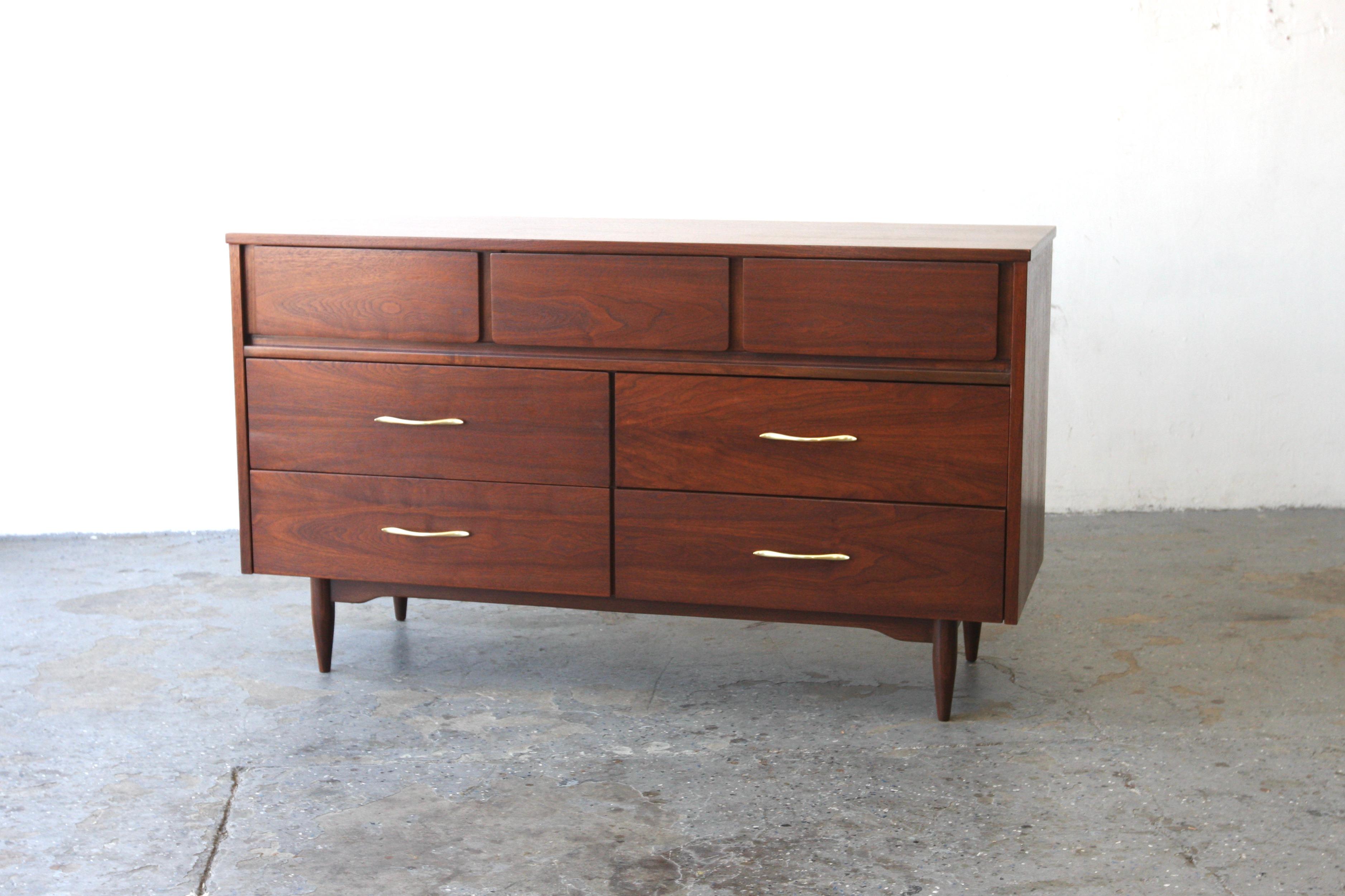 Mid-Century Modern 1960s walnut dresser with seven drawers for Mainline by Hooker Furniture Co. The dresser Professionally Refinished and restored.  Marked in the drawer.

A classic mid-century design dresser with minimalistic characteristics. Its