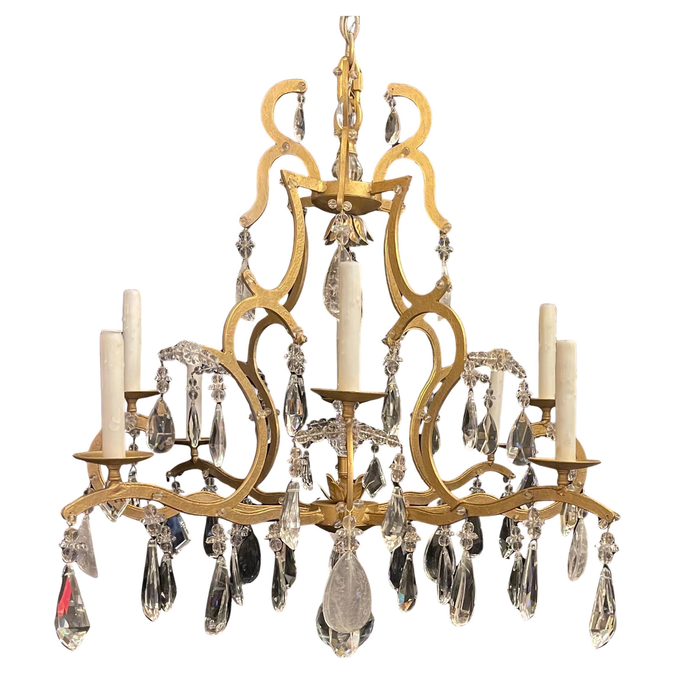 Merveilleux lustre de style Maison Baguès du milieu du siècle dernier en fer doré avec perles et gouttes de cristal et de cristal de roche assorties. Ce magnifique lustre de grande taille a été complété par une grande boule de cristal sur le fond et