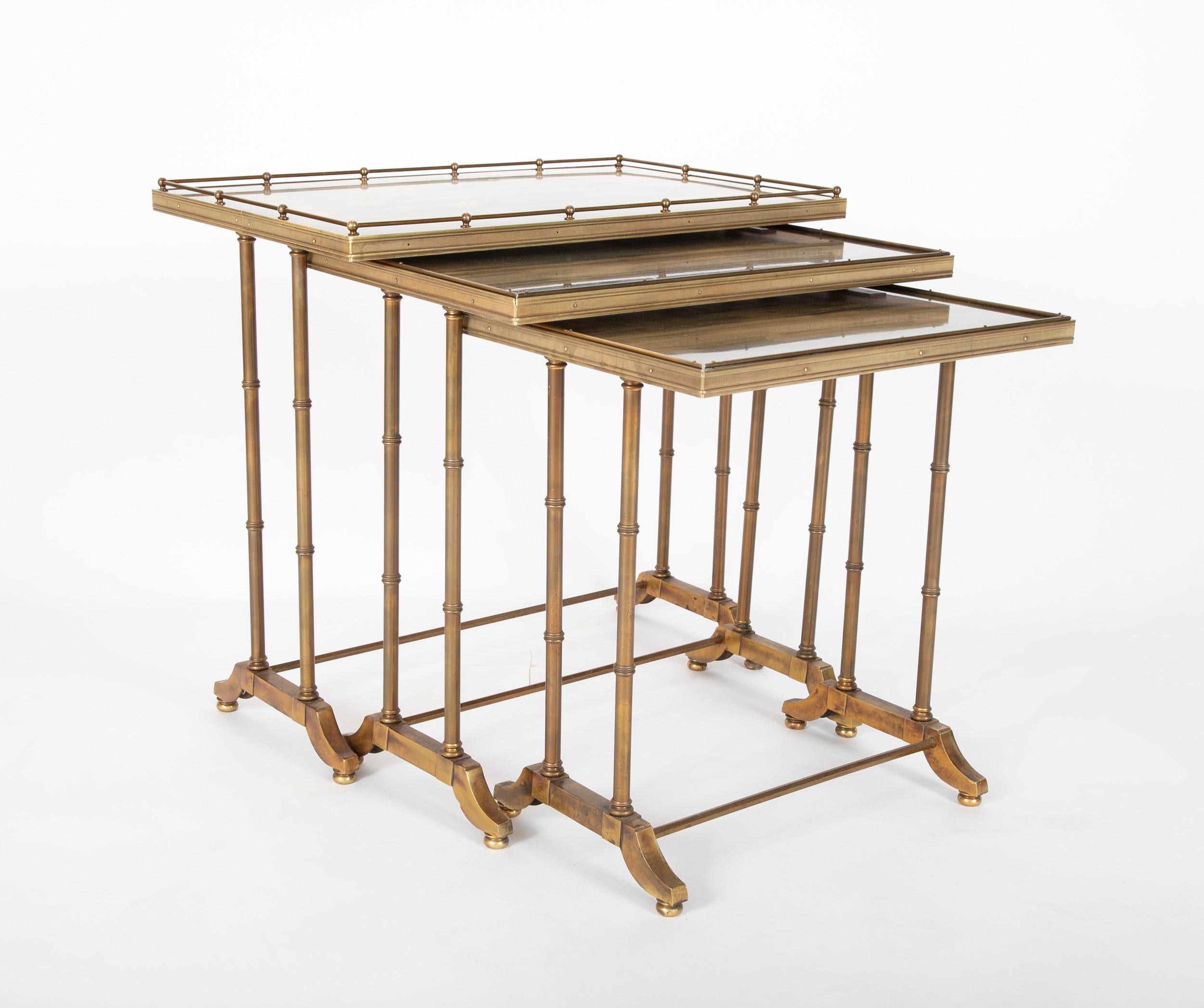 A set of three all brass nesting tables with beautiful patina. The largest with a gallery top, all with round legs resting on bracket feet supported by hexagonal stretchers. A beautiful design combining a modern take on the traditional with an