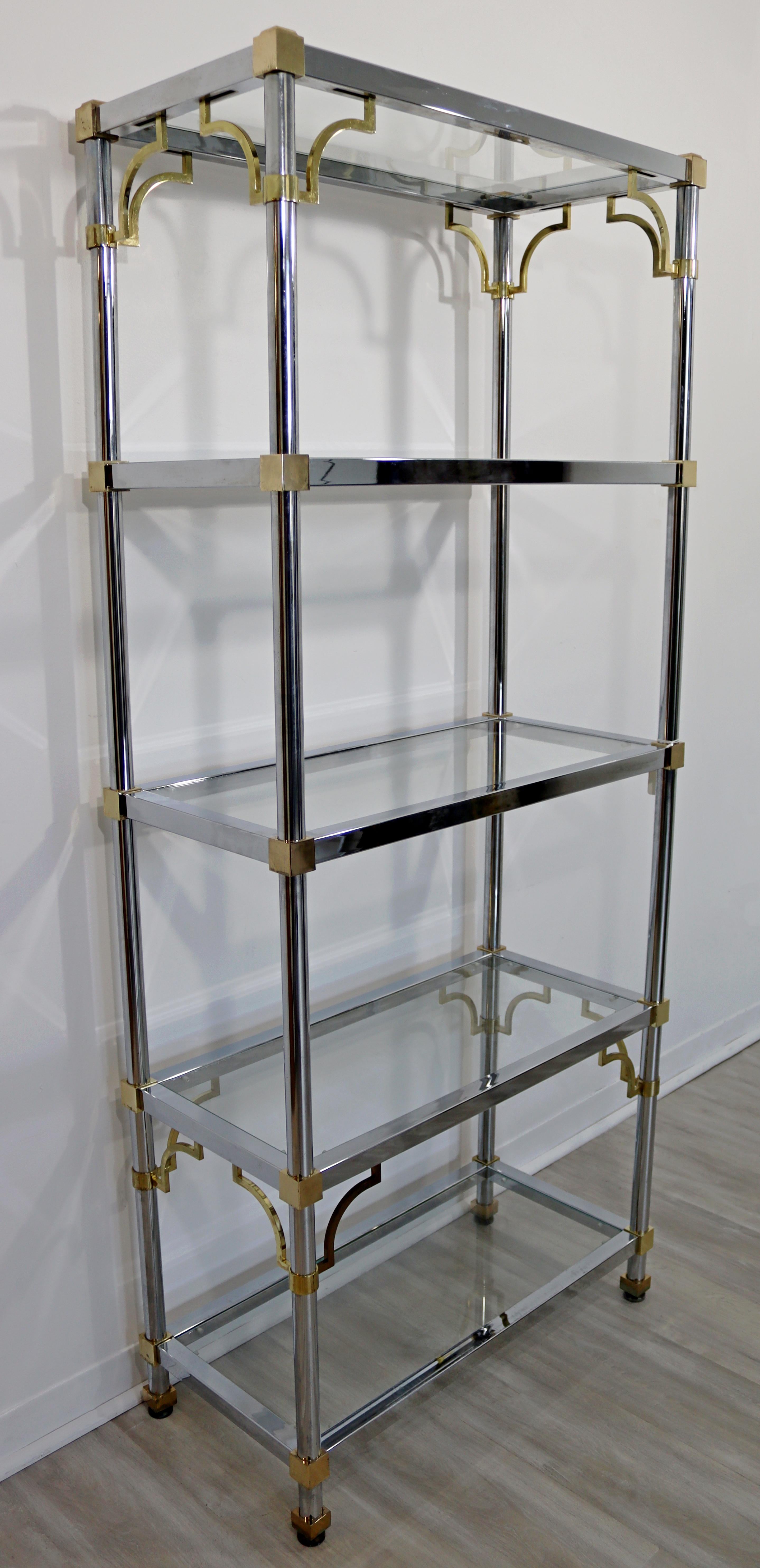 For your consideration is a marvelous, chrome and brass shelving unit etagere, with five glass shelves, by Maison Jansen, circa the 1960s. In very good vintage condition. The dimensions are 31