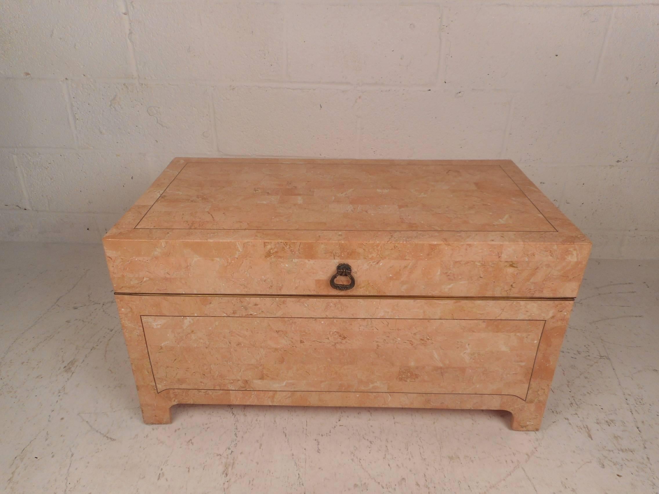 This Mid-Century Modern storage box is made of pink tessellated stone. Brass inlaid trim, unique feet, and an elaborate stone design sets this stylish box apart from others. Three sculpted brass handles offer convenient moving and opening of this