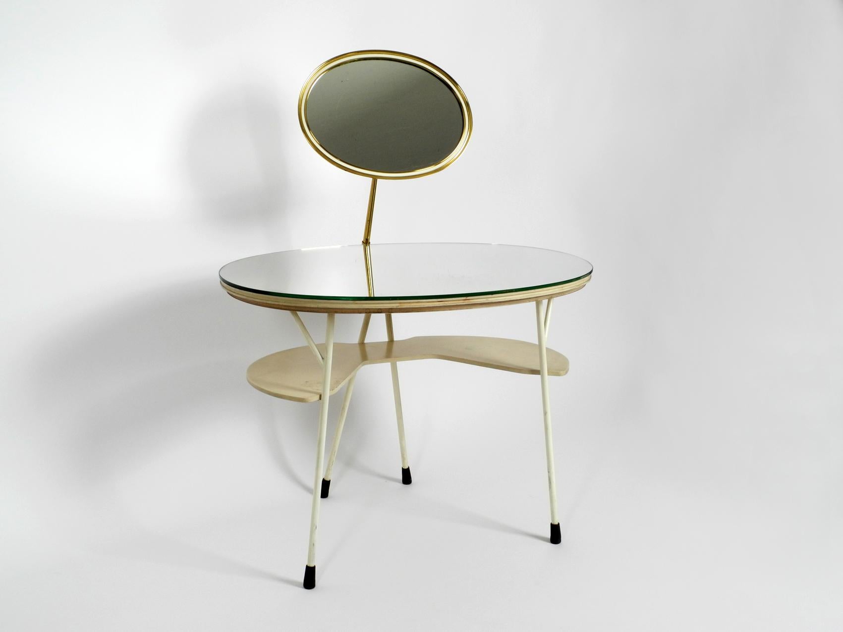 Very rare Mid-Century Modern make up mirror table. 
Manufactured by Vereinigte Werkstätten. Made in Germany. 
The dressing table is made of wood with a mirror surface and a lower shelf made of painted wood. A second oval heavy mirror is attached