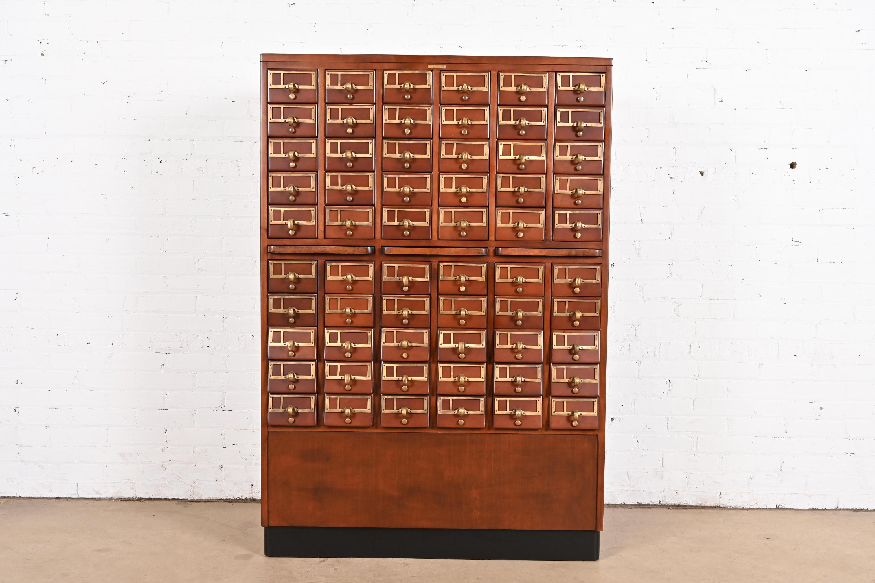 A beautiful Arts & Crafts or Mid-Century Modern 60-drawer library card catalog or file cabinet with three pull-out writing tablets

In the manner of Remington Rand

USA, Mid-20th Century

Maple, with brass hardware and ebonized base.

Measures: