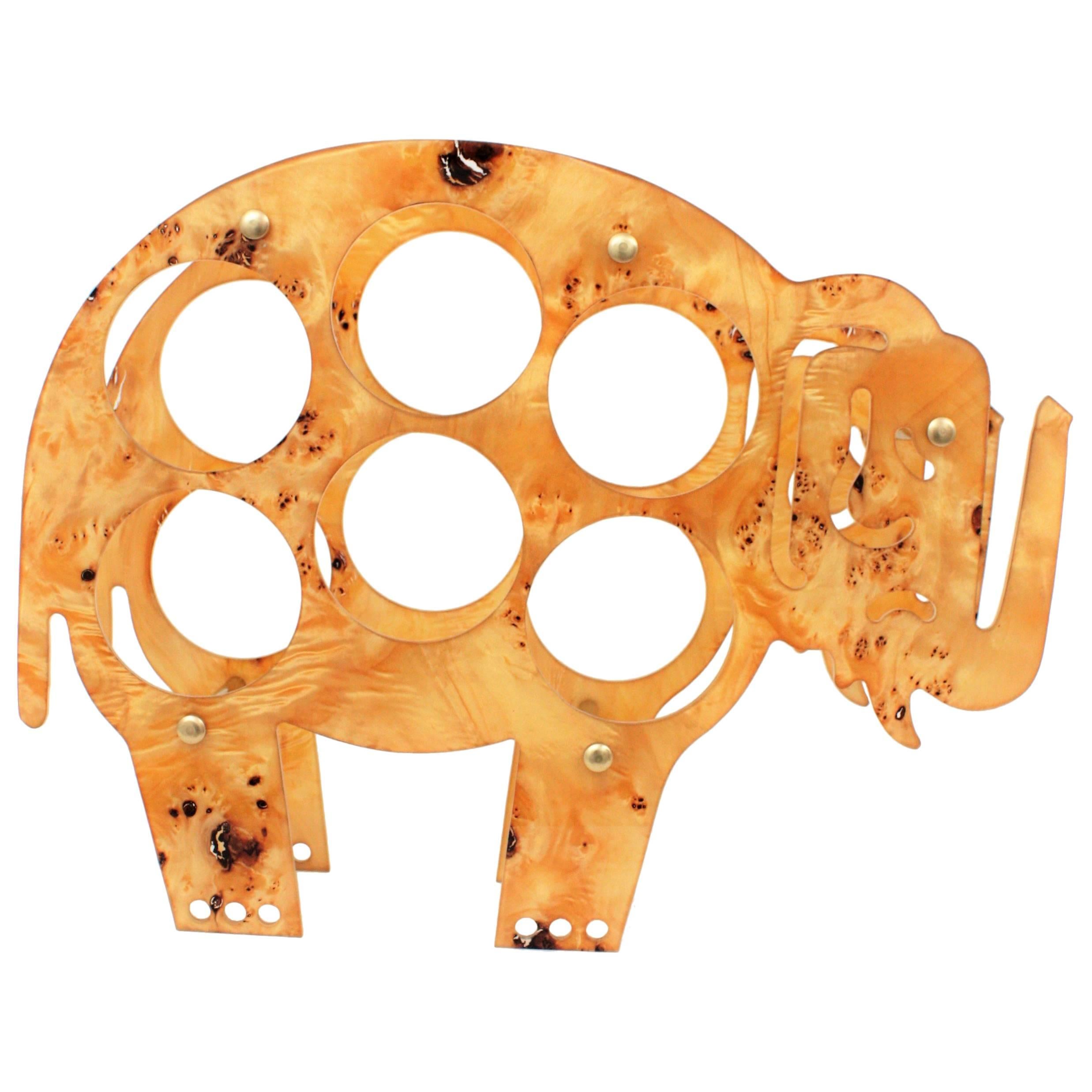 An exquisite maple burl wood, Lucite and brass elephant shaped wine bottle rack or magazine rack. Italy, 1960s.
This piece was manufactured at the midcentury period with maple burl wood cased into acrylic transparent Lucite and brass finials to