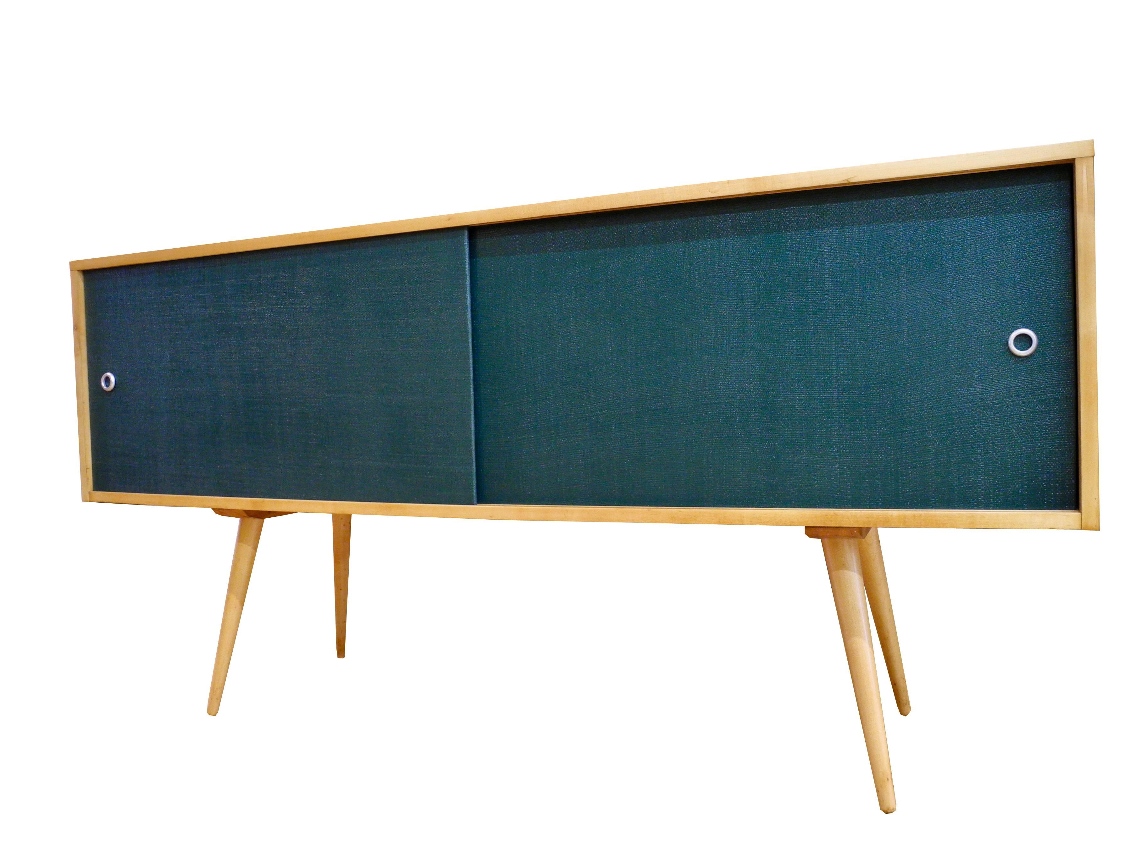 This modern sideboard designed by Paul McCobb has two sides both equipped with a shelf.
Made of a solid natural maple wood case with sliding doors painted forest green, it provides good storage. Restored and refinished.
