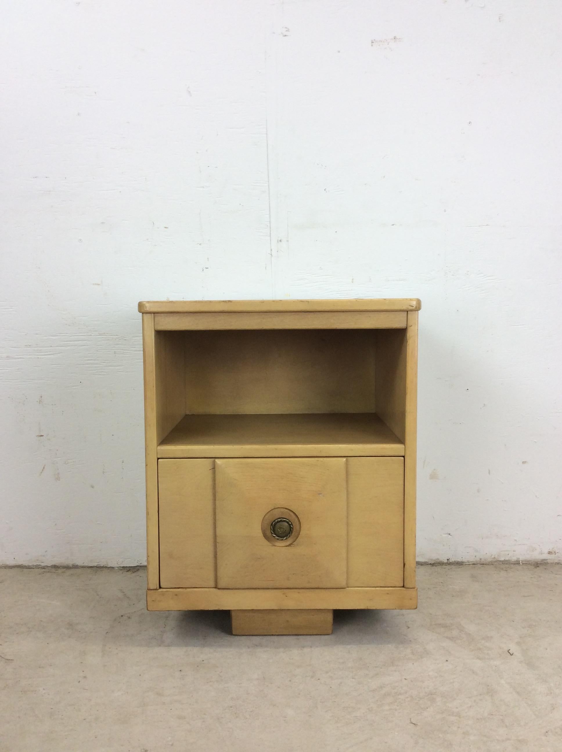 This Mid century modern nightstand features hardwood construction, original blonde finish, single dovetailed drawer with brass accented hardware, opened storage above the drawer and short tapered legs.

Dimensions: 18.5w 15d 23.25h  

Condition