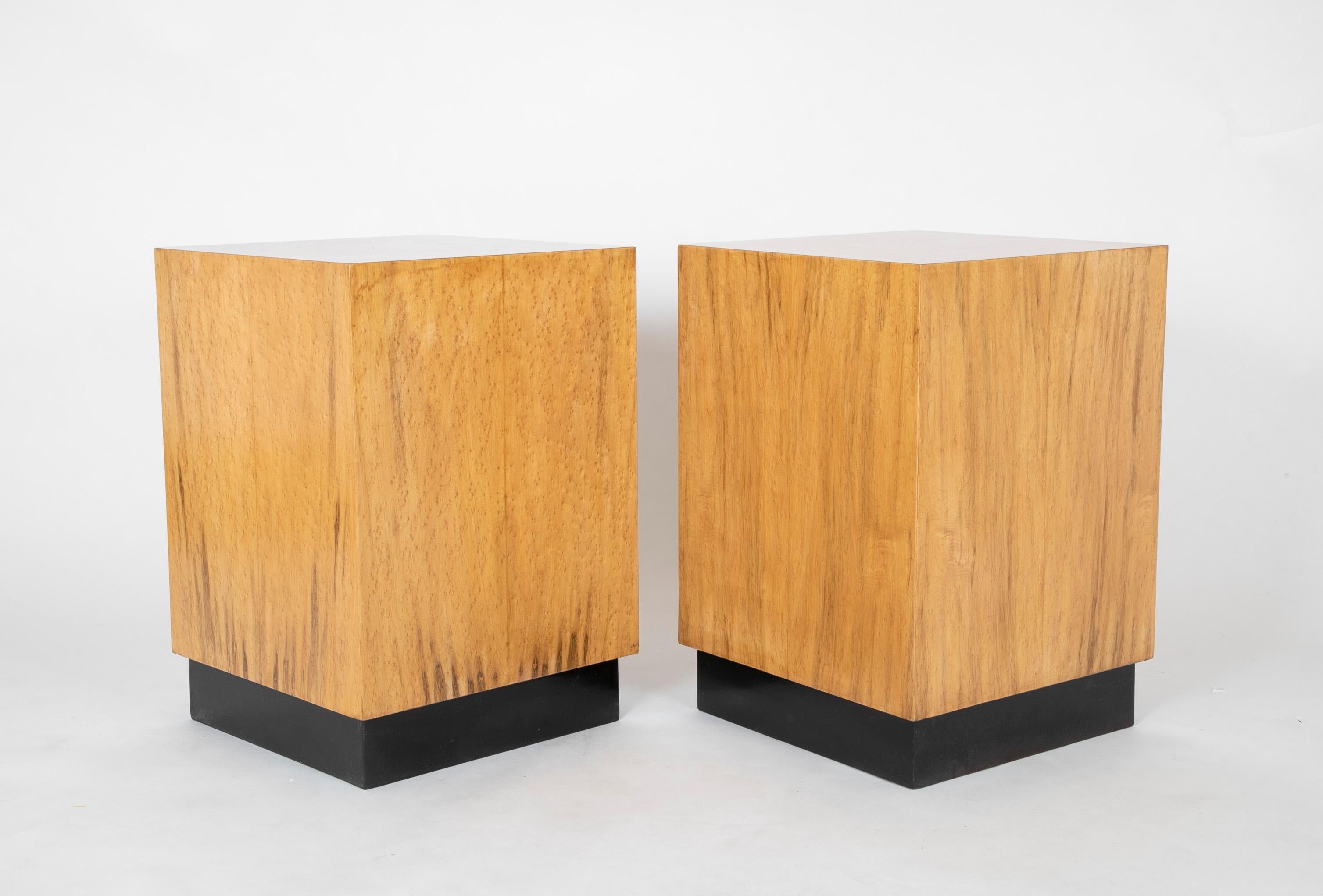 Great looking pair of mid 20th century cube-form side tables covered in birds-eyes maple veneer, on recessed black bases. These make very distinctive end tables or pedestals. At 25.5 inches high, they are perfect for either side of living room