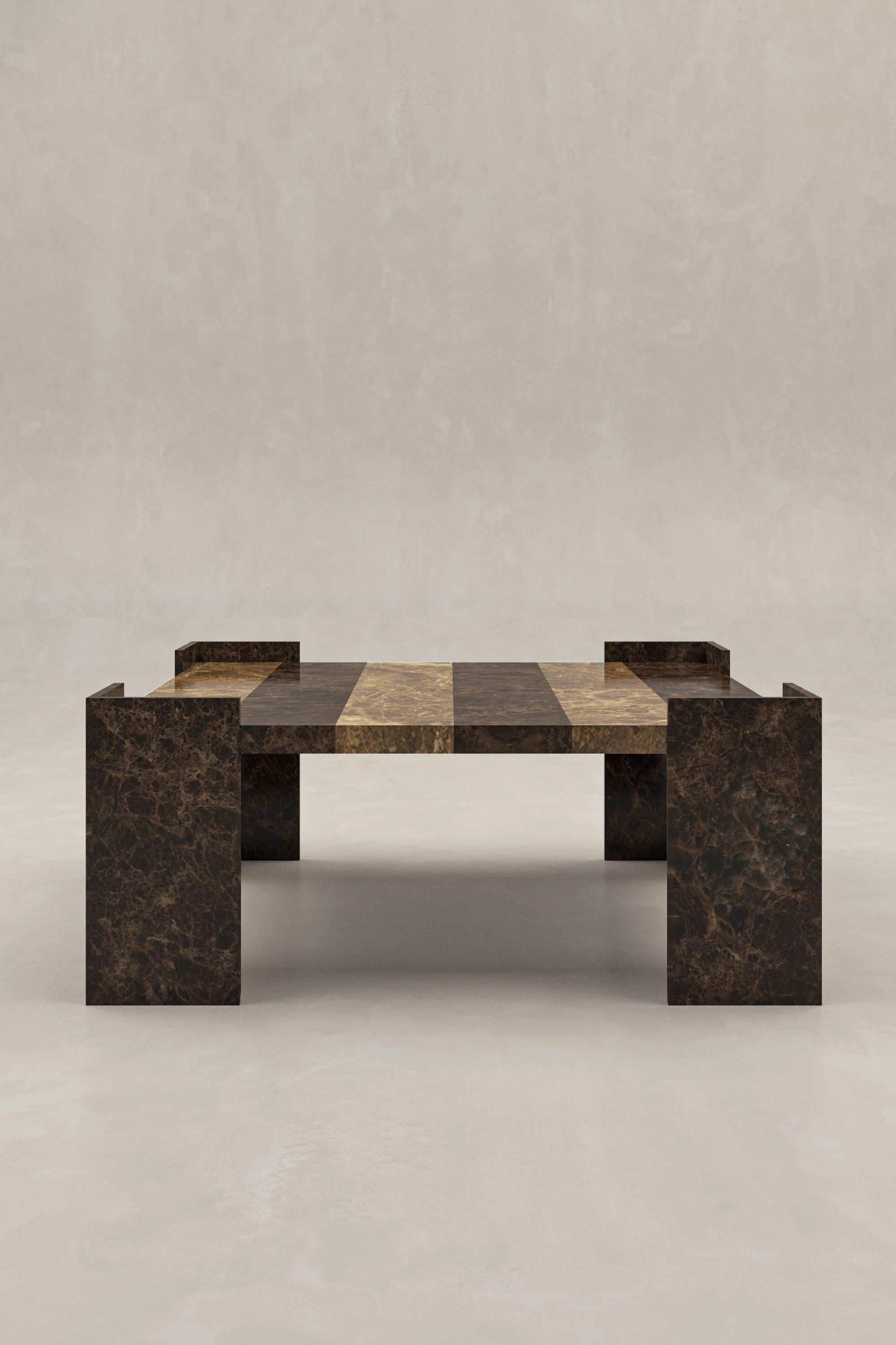 La table basse Hensen est un chef-d'œuvre sculptural, fabriqué à la main à partir de marbre Emperador moyen et Emperador foncé, importé d'Espagne. Sa forme architecturale audacieuse et sa finition mate adoucie mettent en valeur le riche veinage brun