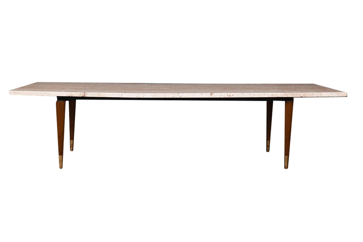 Beautiful mid century marble coffee table bench. Features a thick slab of colored removable custom marble top, resting on a metal frame supported on brass tipped walnut tapered pencil legs. An Iconic retro marble coffee table, that can be used as a