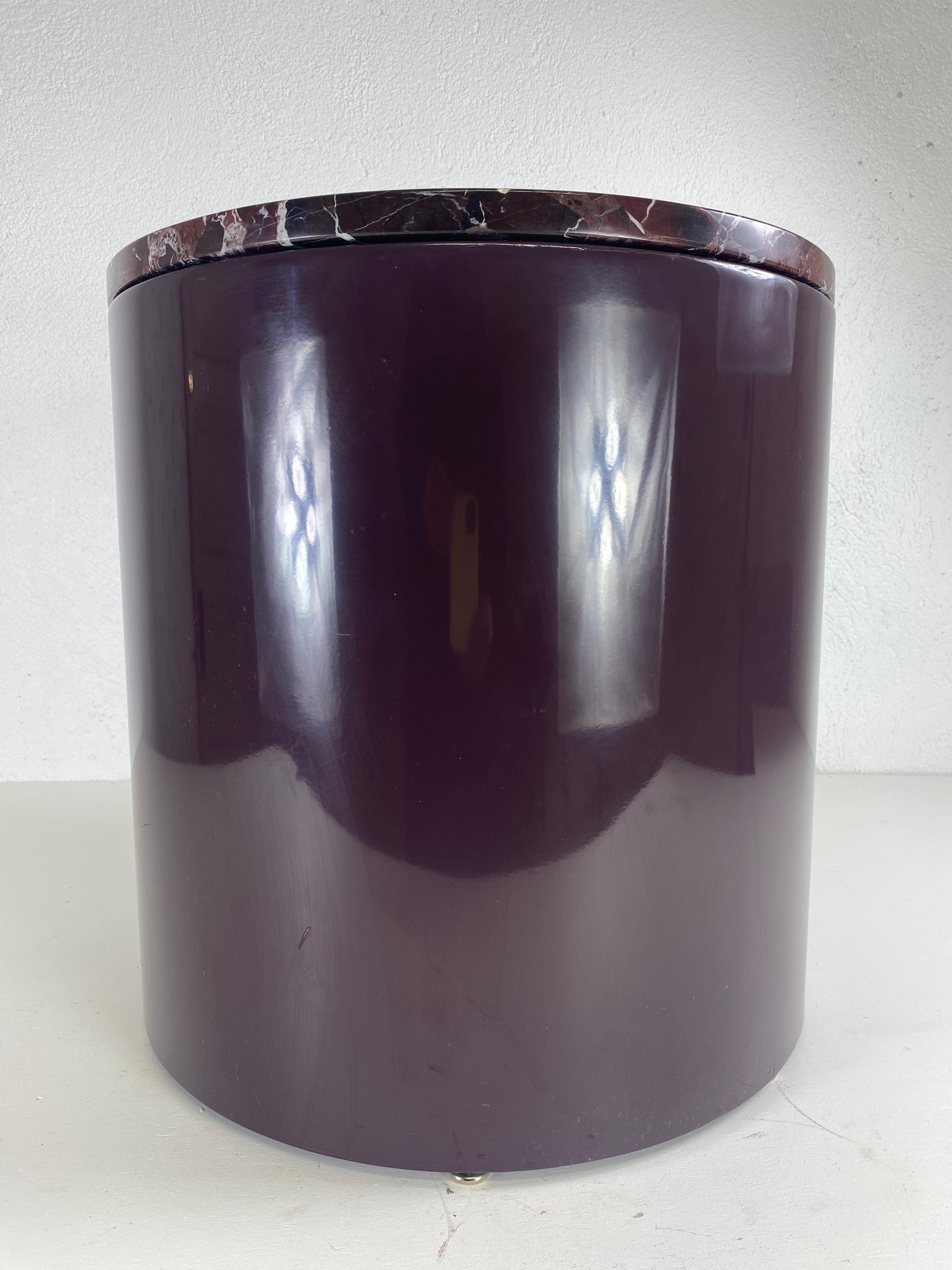 This is a mid century modern lacquered marble top pedestal or side table. This pedestal has a deep eggplant lacquered finish to the base with an elegant and black vein marble top. This pedestal table is American made circa 1970.