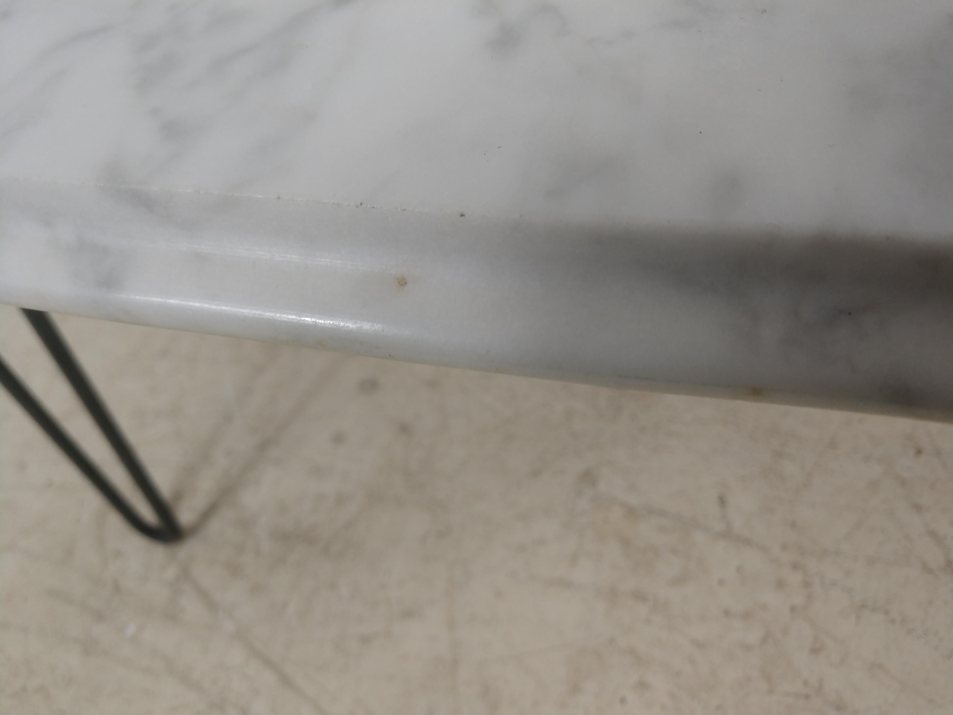 Fabulous Carrara marble-top cocktail table in the form of a surfboard. White marble from Italy, with 3 hairpin legs attached to a board underneath. Marble sits comfortably on top with no teetering. 1 small flea bite to the underside.