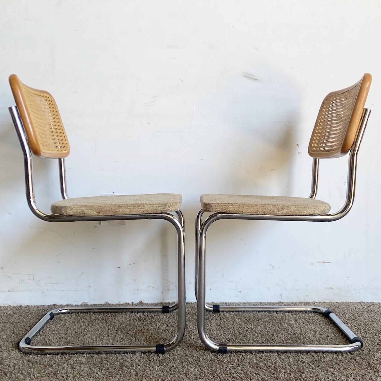 Immerse yourself in mid-century design with this set of four Marcel Breuer Style Cane and Chrome Cantilever Dining Chairs. These chairs feature chrome cantilever frames, cane backrests, and beige fabric seats, offering a perfect blend of comfort and