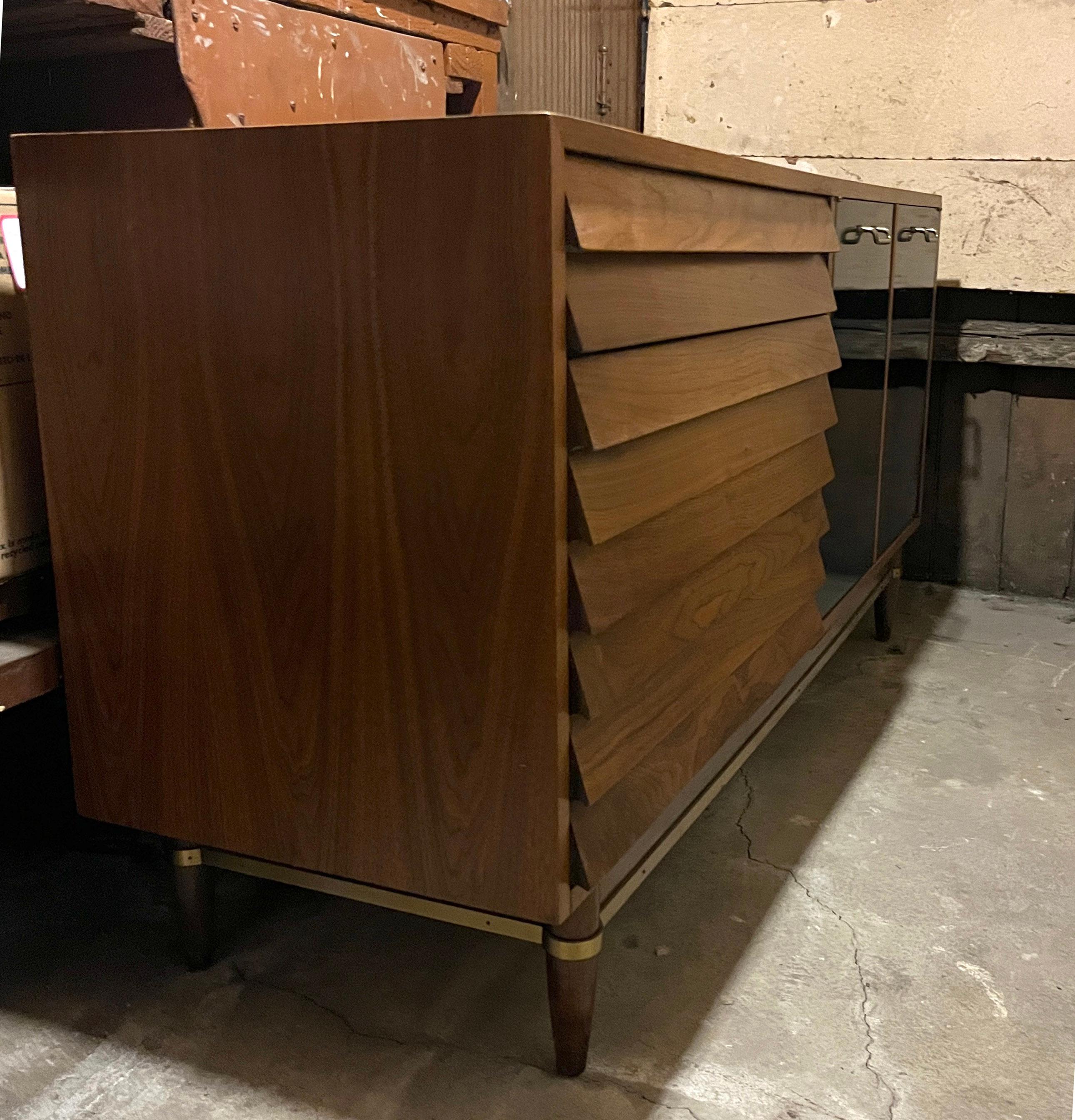 Ausgezeichneter Originalzustand American of Martinsville Anrichte oder Lowboy Kommode entworfen von Merton Gershun. Hergestellt aus echtem Nussbaumholz mit lackierten Schubladenfronten und Messingdetails. 

Mit einem Rahmen aus Nussbaumholz und drei