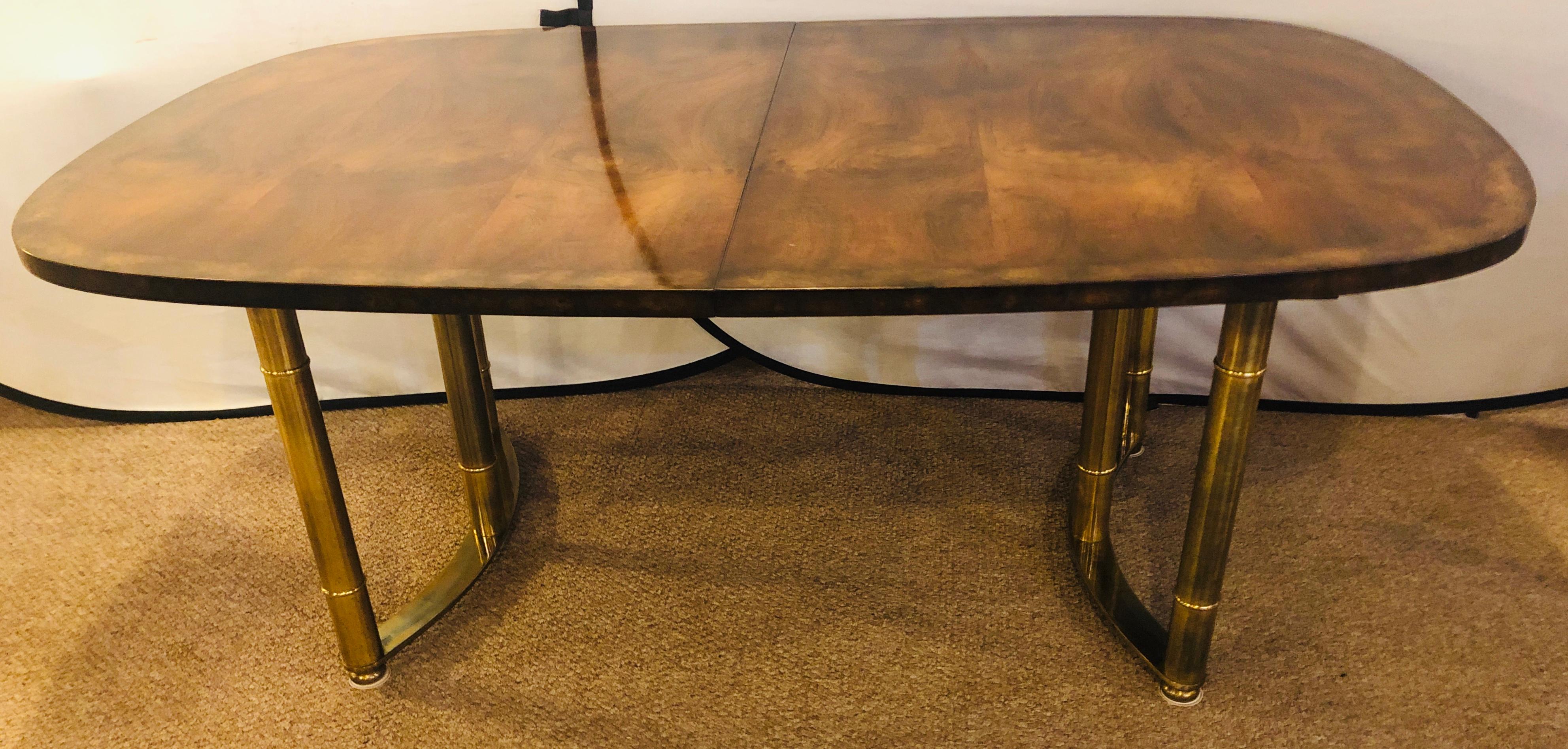 Mid-Century Modern Mastercraft bamboo form brass legged and burl wood dining room table. This finely constructed dining table by this highly sought after design firm is simply stunning. The table having three twenty inch leaves (two never having